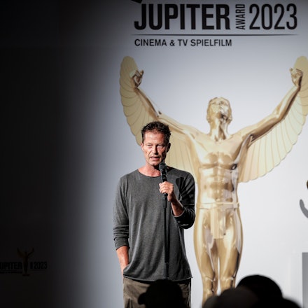 Schauspieler Til Schweiger hält auf einer Bühne eine Laudatio.