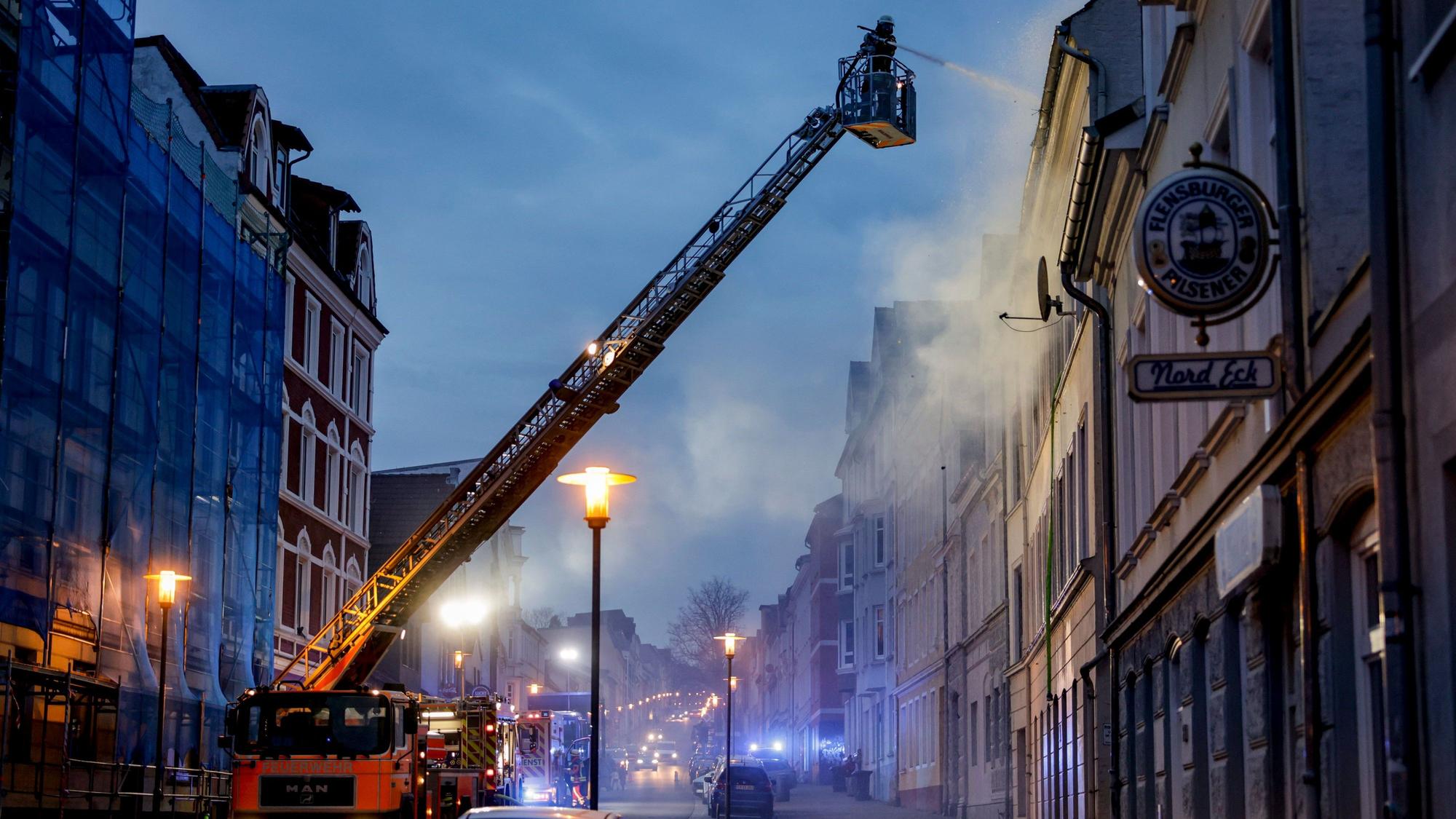 04.05.2023, Schleswig-Holstein, Flensburg: Die Feuerwehr ist bei einem Brand in der Flensburger Neustadt im Einsatz. Bei dem Brand eines zweieinhalbgeschossigen Mehrfamilienhauses sind zwei Menschen ums Leben gekommen. Foto: Axel Heimken/dpa +++ dpa-Bildfunk +++