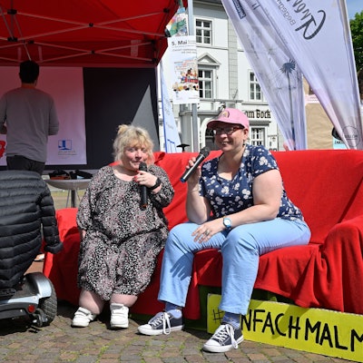 Aktion Inklusionsbeirat zum Protesttag zur Gleichstellung von Menschen mit Behinderung mit einer roten Couch.