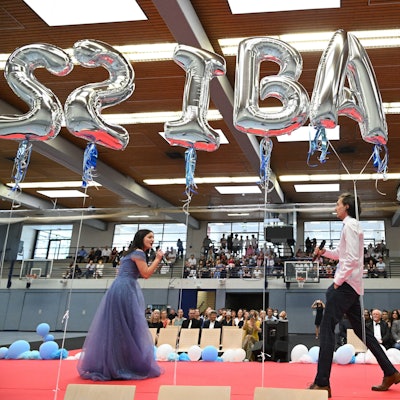 Zwei Schüler des Abi-Jahrgangs stehen auf der Bühne und singen.