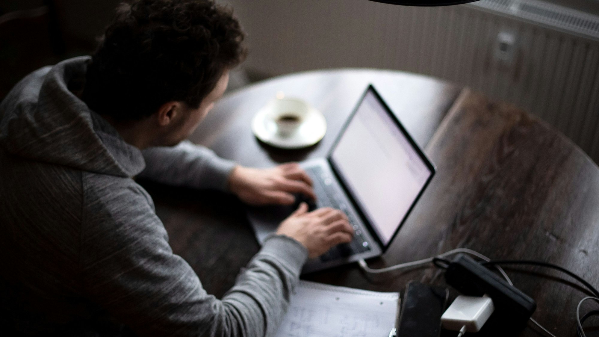 Ein Mann sitzt an einem Laptop.