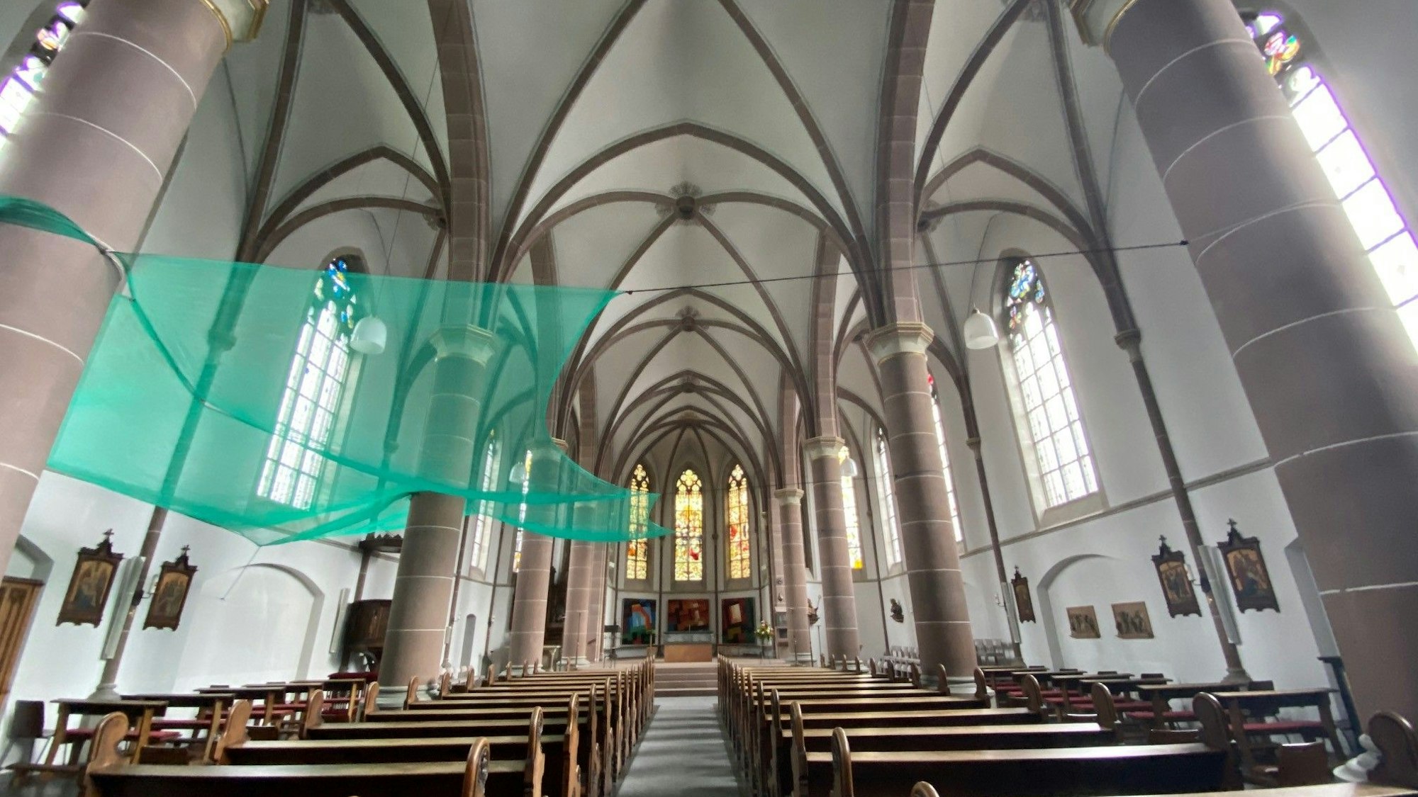 Ein Blick in den Innenraum der Kirche. Über der linken Seite hängt ein grünes Netz.