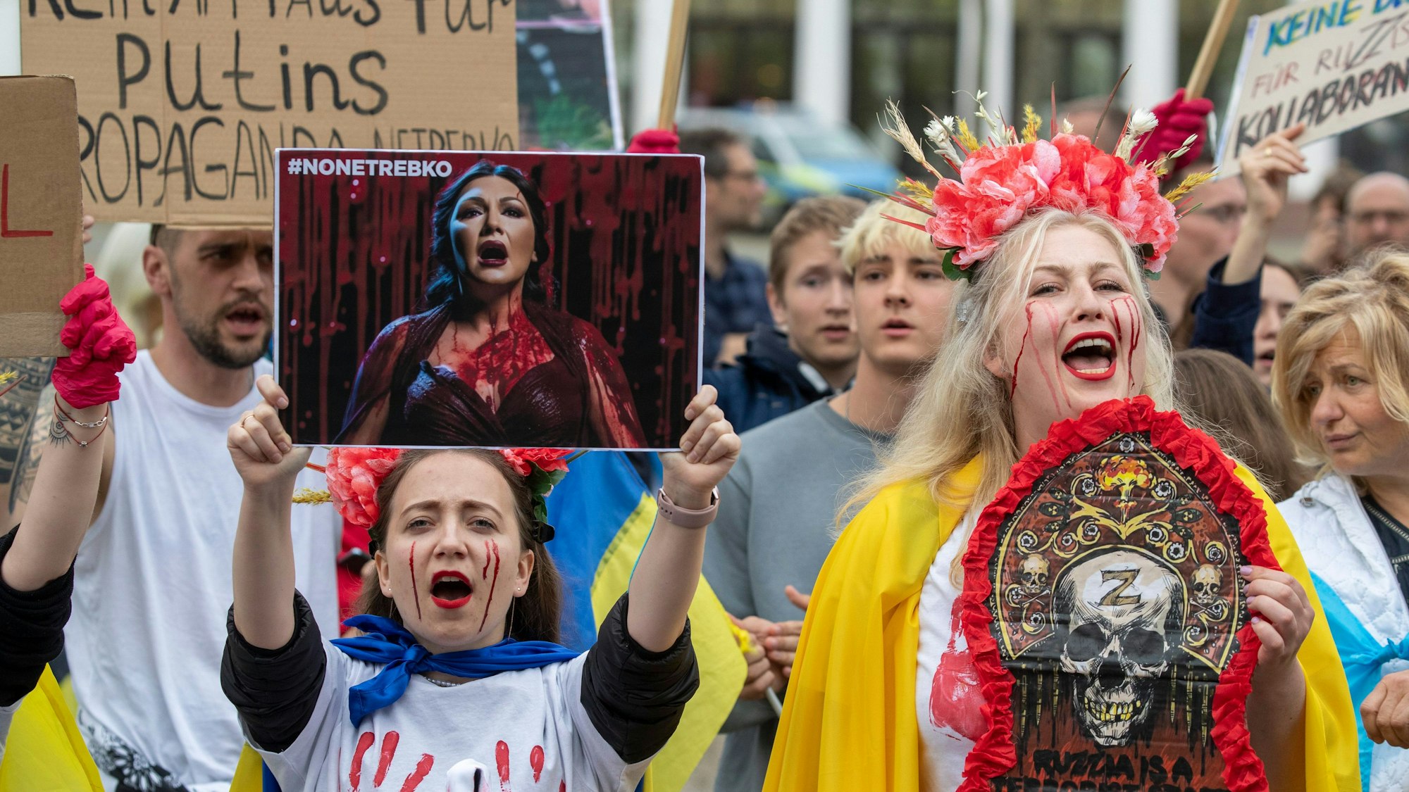 05.05.2023, Hessen, Wiesbaden: Demonstranten üben Solidarität für die Ukraine und gegen den Auftritt von Anna Netrebko im Staatstheater in Wiesbaden während der Maifestspiele. Hunderte Menschen haben vor dem Hessischen Staatstheater gegen den Auftritt der russischen Starsopranistin Anna Netrebko demonstriert. Foto: Helmut Fricke/dpa - ACHTUNG: Nur zur redaktionellen Verwendung und nur mit vollständiger Nennung des vorstehenden Credits +++ dpa-Bildfunk +++