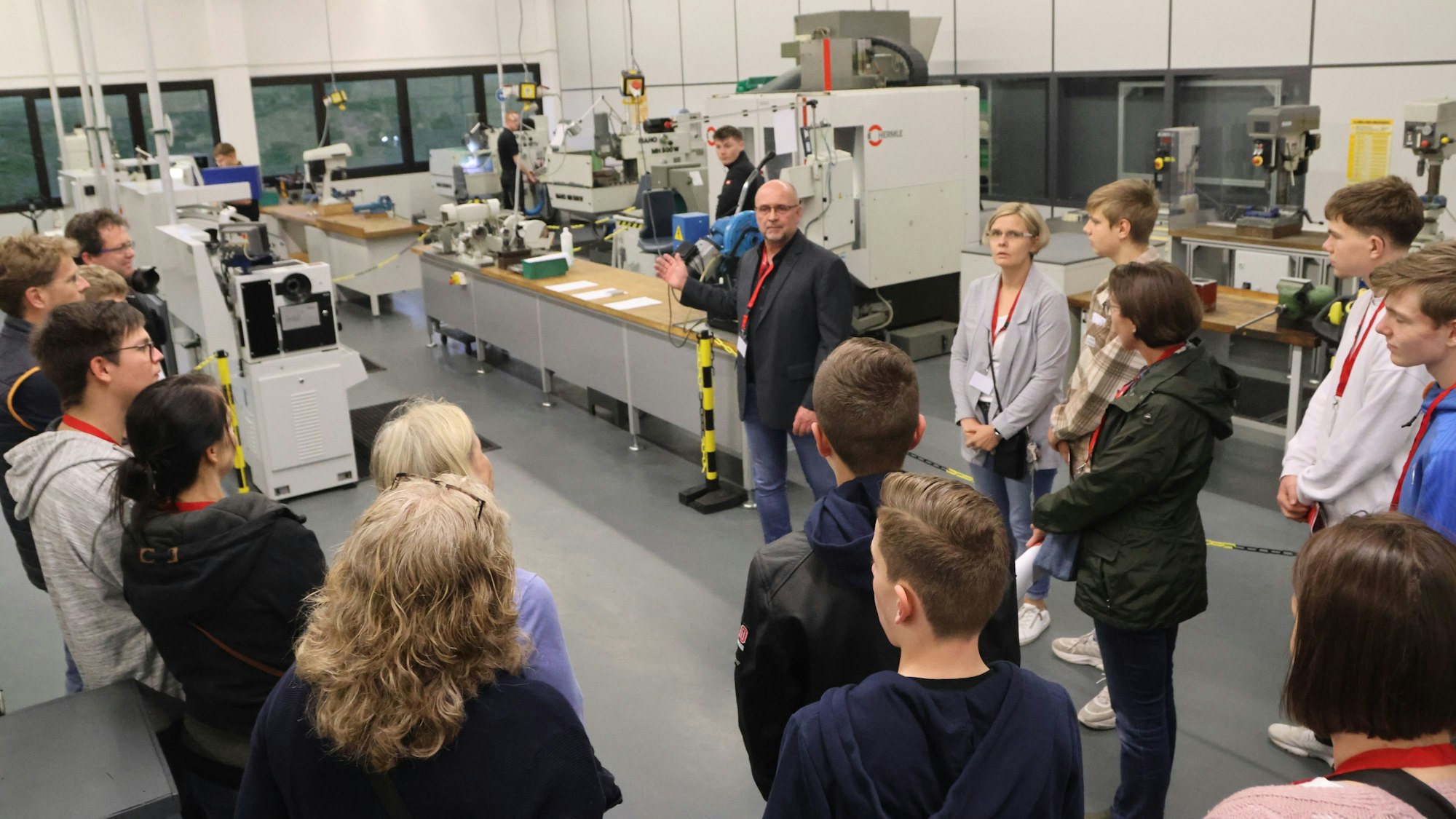Ein Mann führt eine Gruppe durch die Produktionshallen eines Unternehmens.