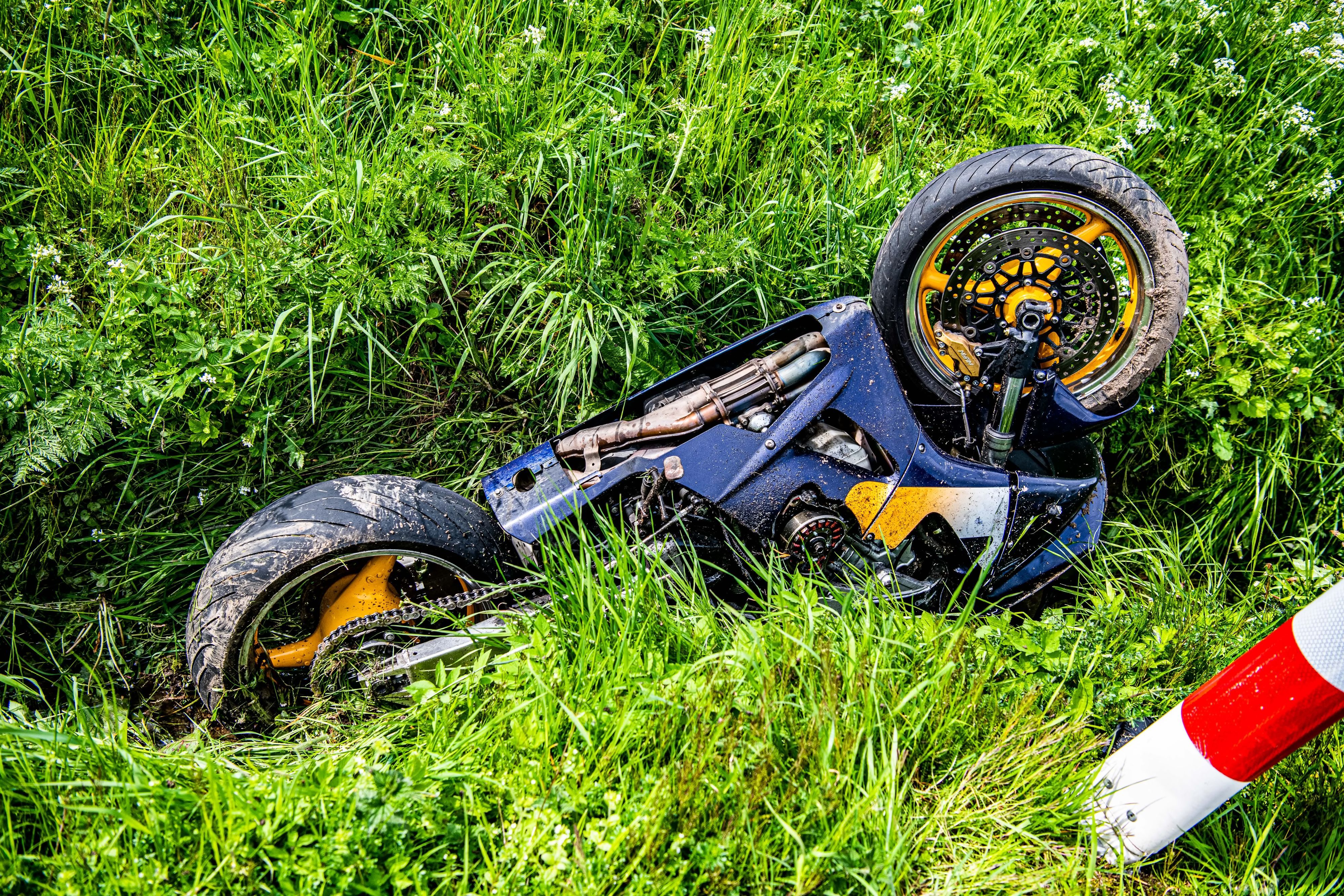 Ein Motorrad liegt nach Verkehrsunfall  mit PKW-Beteiligung im Straßengraben.