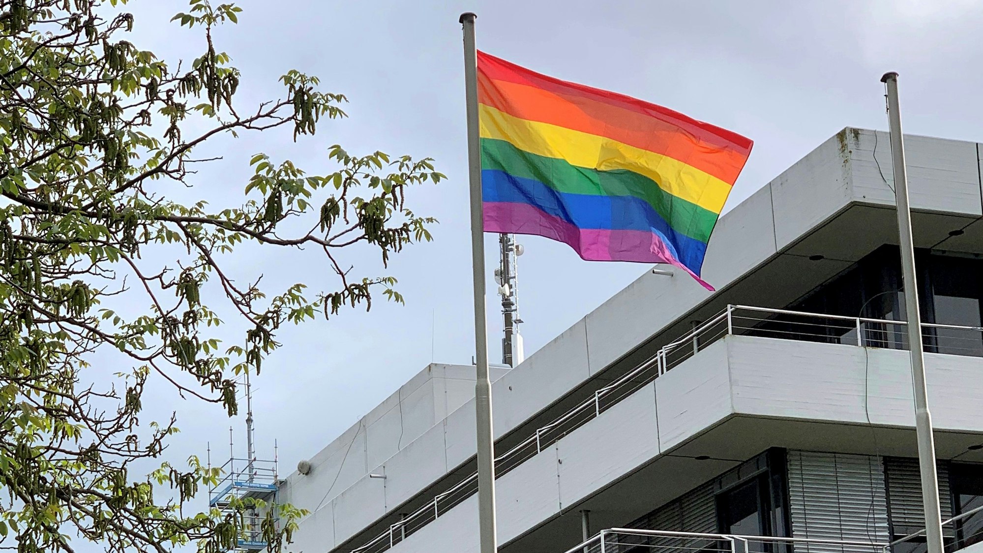 Vor dem Kreishaus in Euskirchen weht eine Regenbogenfahne im Wind.