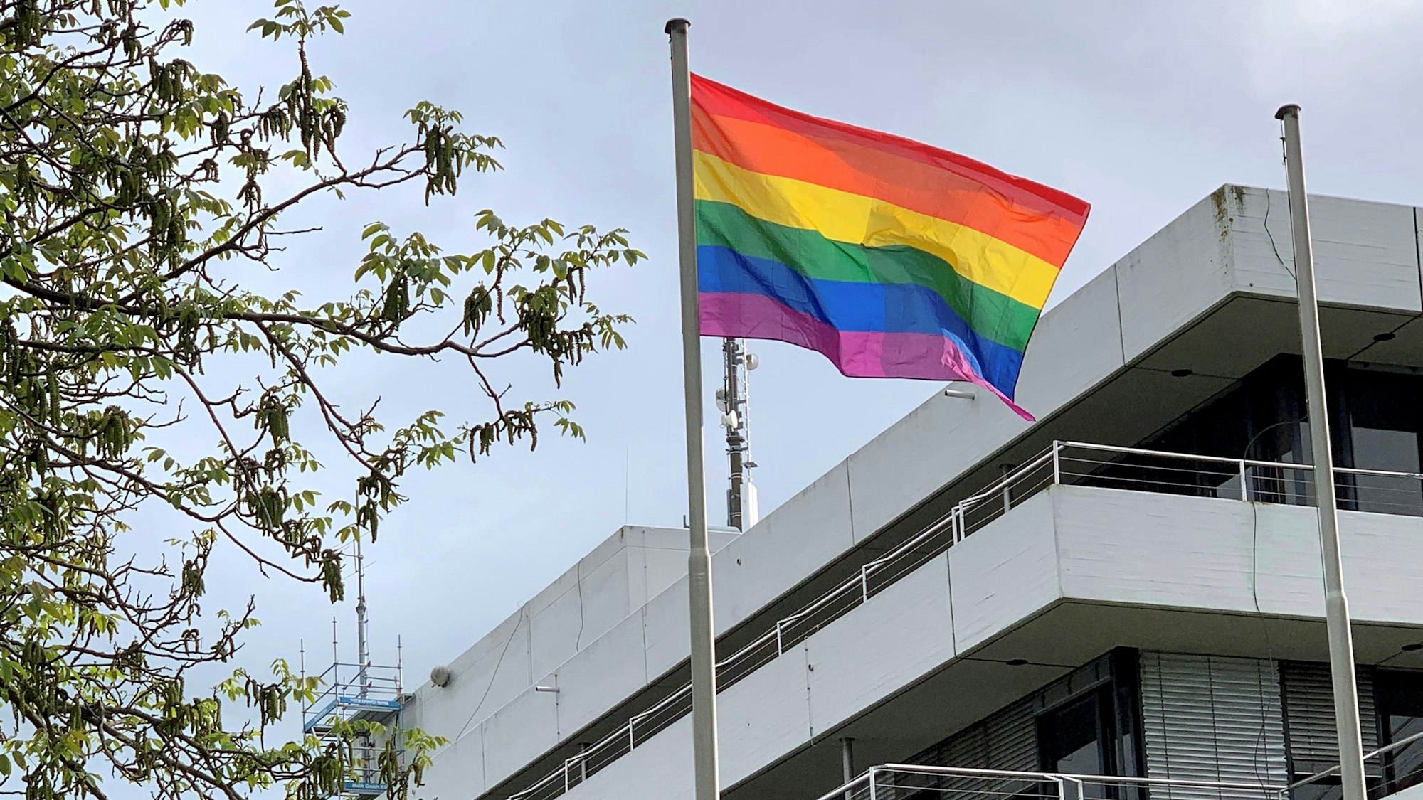 Vor dem Kreishaus in Euskirchen weht eine Regenbogenfahne im Wind.