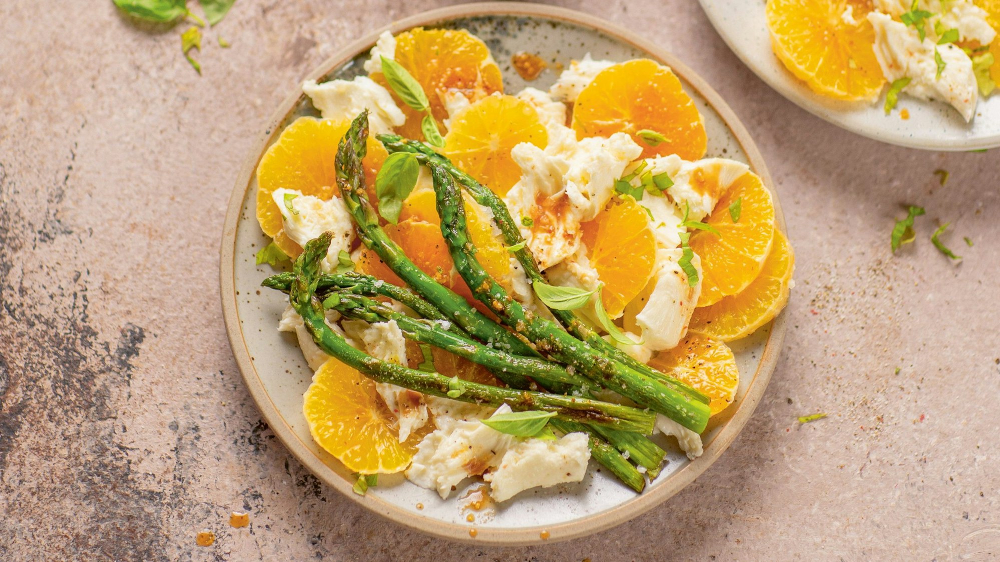 Orangenscheiben, Mozzarella und grüner Spargel angerichtet auf einem Teller