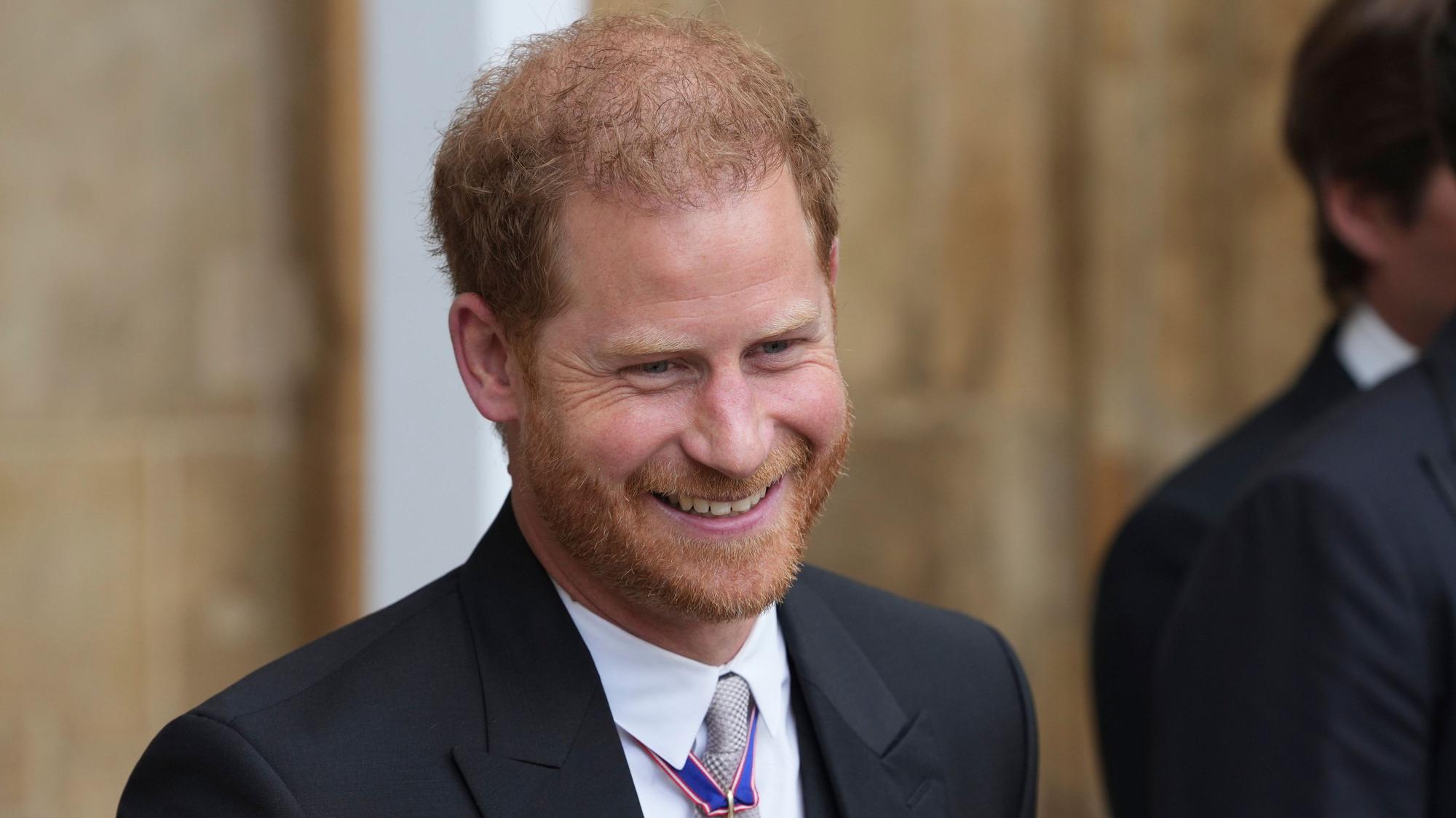 Prinz Harry, Herzog von Sussex, verlässt nach der Krönung von König Charles III. und Königin Camilla die Westminster Abbey und lächelt.