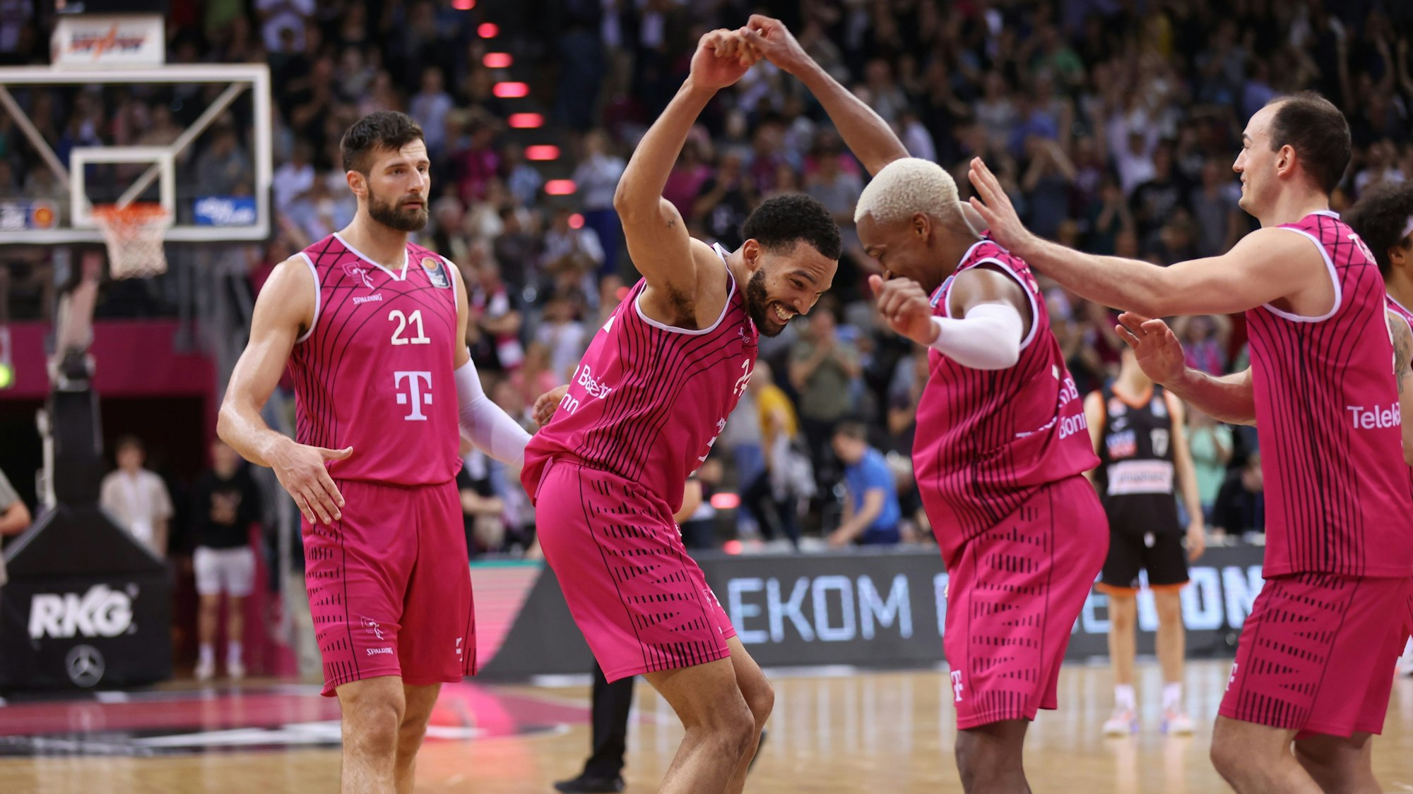 TJ Shorts (2.v.r.) feiert mit Deane Williams, Karsten Tadda (r.) und Leon Kratzer (l.) den Sieg.