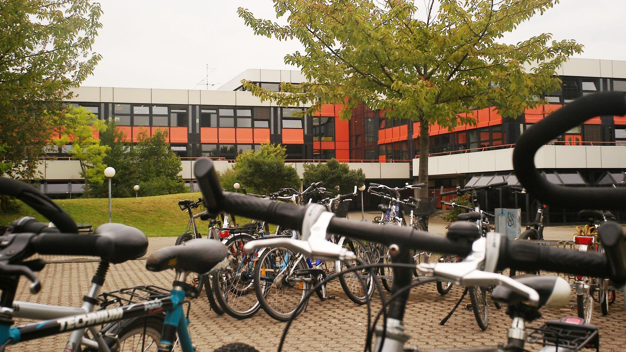 Auf dem Foto ist der Fahrradparkplatz der Europaschule in Kerpen zu sehen, Im Hintergrund ist das Schulgebäude zu sehen.