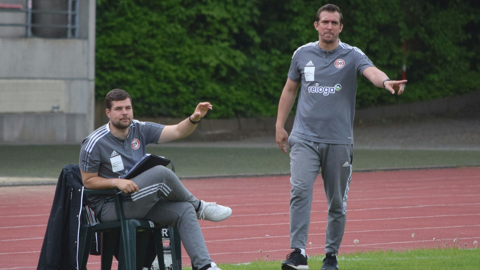 Andreas Dreiner steht und Tobias Felser sitzt an der Seitenlinie