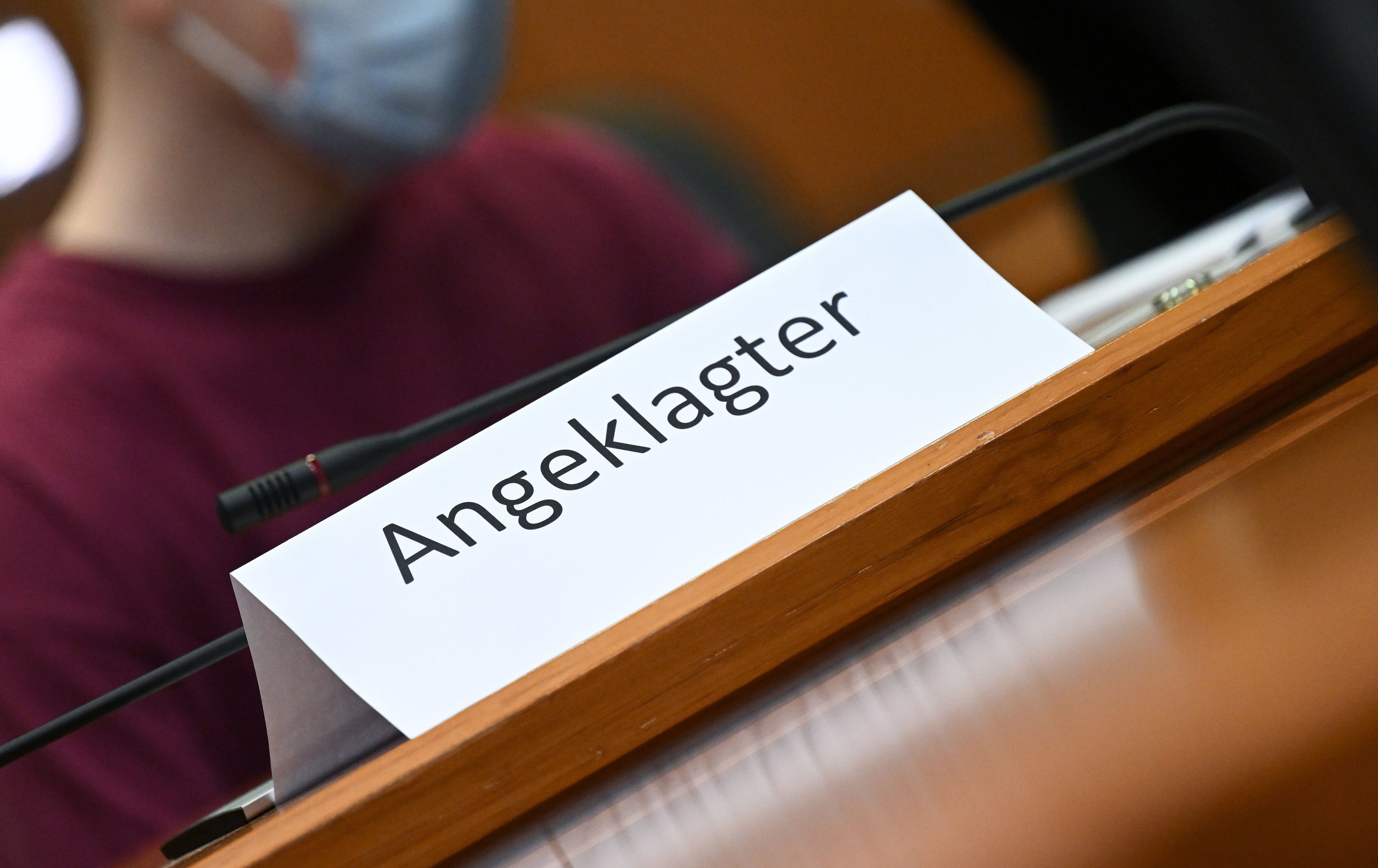 02.08.2022, Hessen, Frankfurt/Main: Der Angeklagte hat im Gerichtssaal des Oberlandesgerichts Frankfurt zum Prozessauftakt Platz hinter einem Schild mit der Aufschrift „Angeklagter“ genommen.