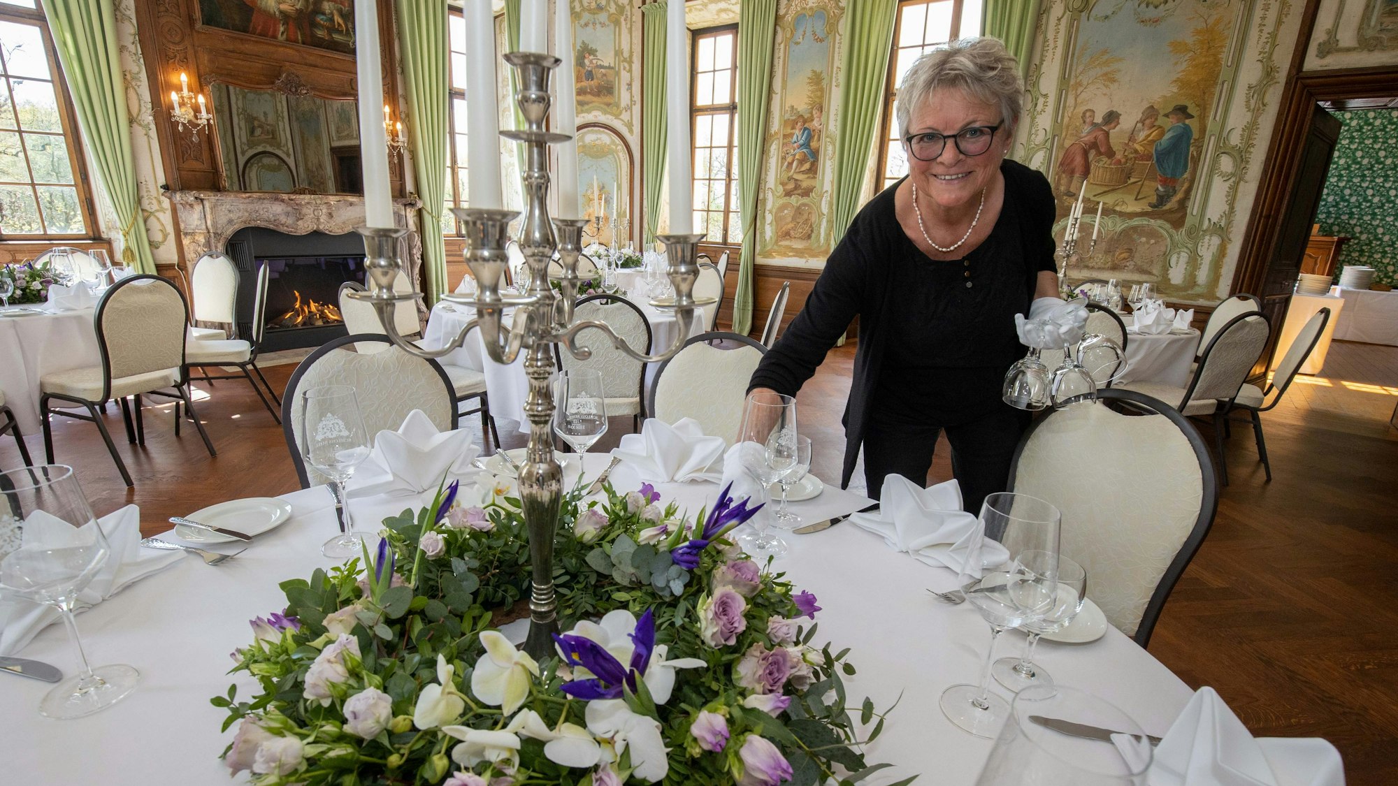 Birgit Schroden deckt einen Tisch ein.