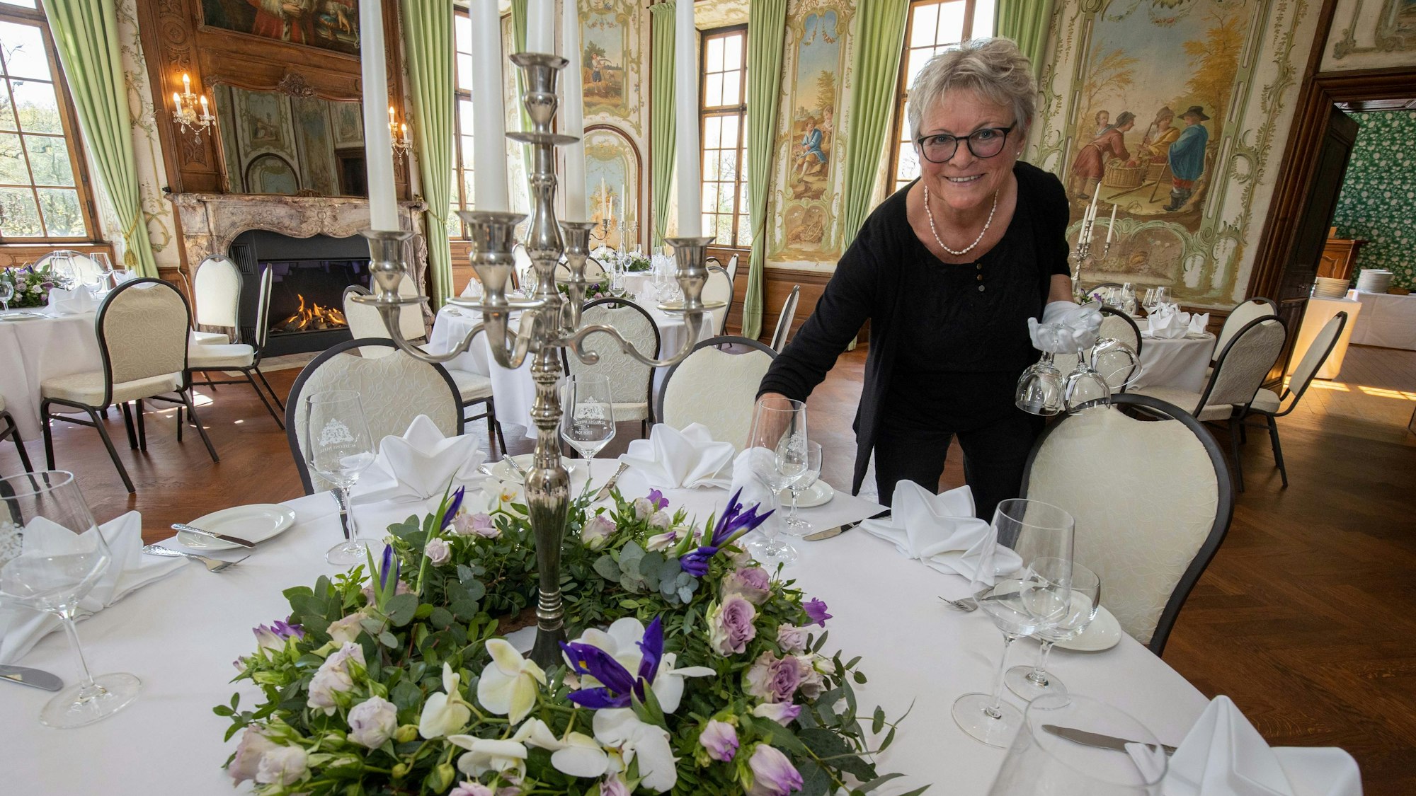 Birgit Schroden deckt einen Tisch ein.