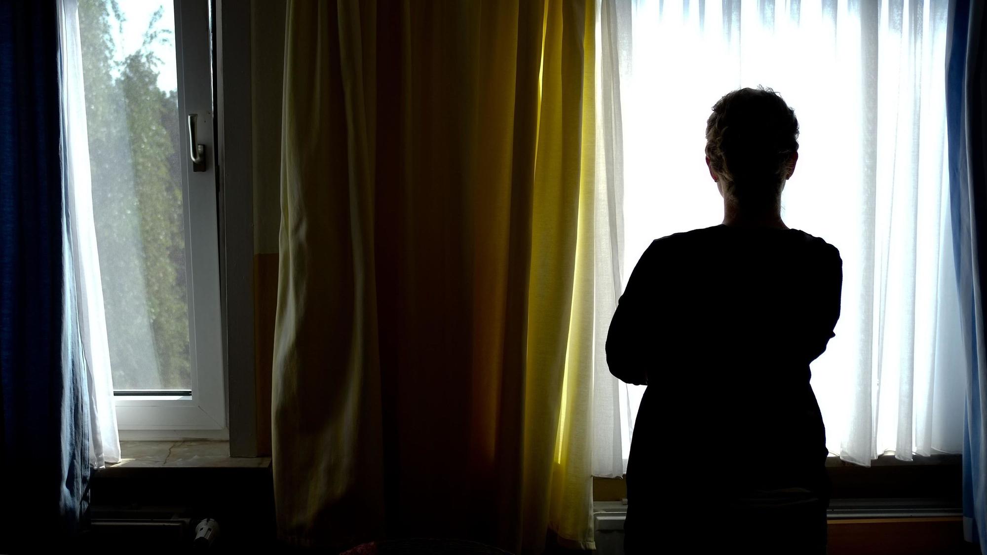 ARCHIV - 28.08.2013, Niedersachsen, Nienburg: Eine Frau steht vor einem Fenster und ist im Gegenlicht nur als dunkle Silhouette erkennbar. Seelische Beschwerden wie Depressionen oder Ängste setzen zunehmend auch die baden-württembergische Wirtschaft unter Druck. Nach Angaben der Barmer-Krankenkasse sind psychische Probleme im vergangenen Jahr verantwortlich gewesen für fast jeden vierten krankheitsbedingt ausgefallenen Arbeitstag. (Illustration zu dpa «Seelenleiden im Wartezimmer - immer mehr Fehltage wegen der Psyche») Foto: Peter Steffen/dpa +++ dpa-Bildfunk +++