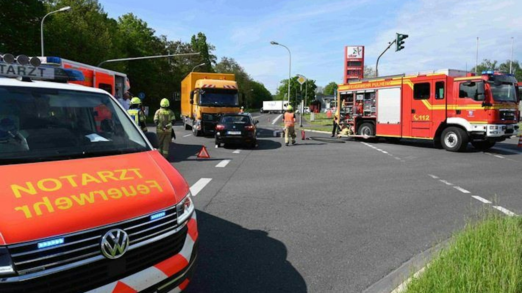 Ein Auto und ein Lastwagen stehen auf einer Kreuzung inmitten von Einsatzfahrzeugen.