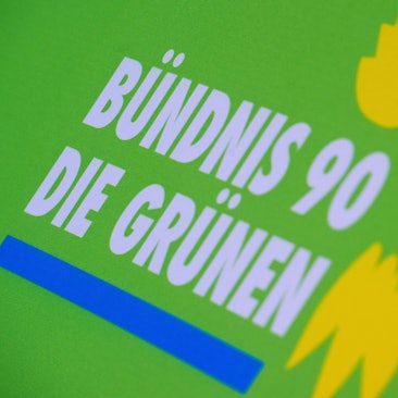 Das Logo von Bündnis 90/Die Grünen steht auf einem Aufsteller der Partei.