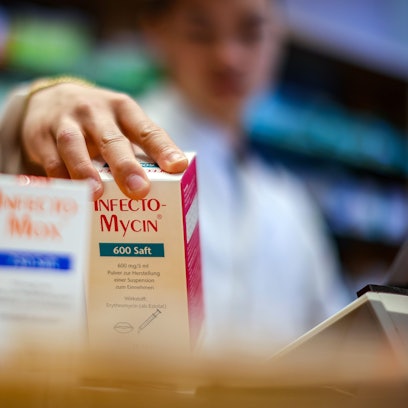 Ein Apotheker greift nach Medikamentenpackungen.