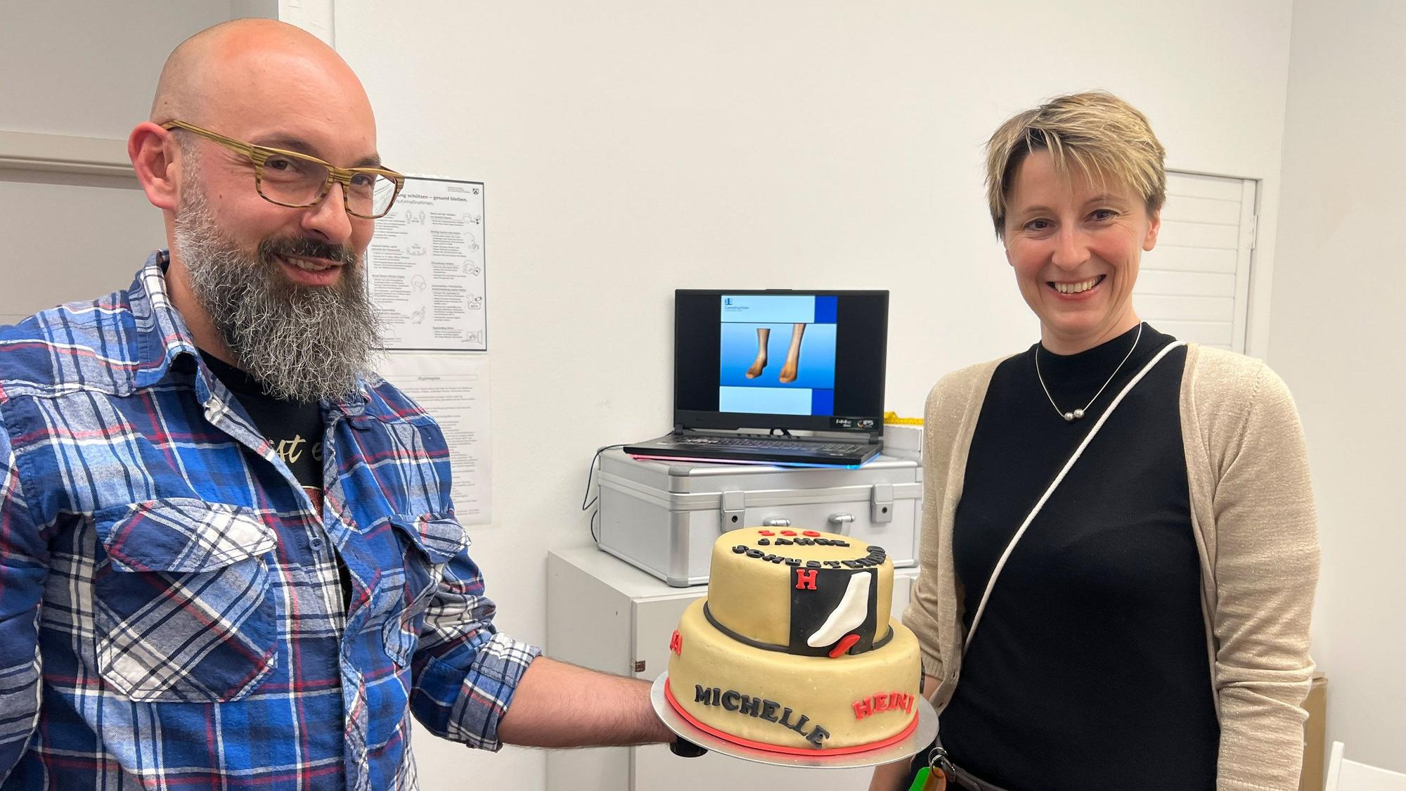Thomas Ohlig, Orthopädie-Schumachermeister und Inhaberin Jessica Hohenschon mit der Geburtstagstorte.