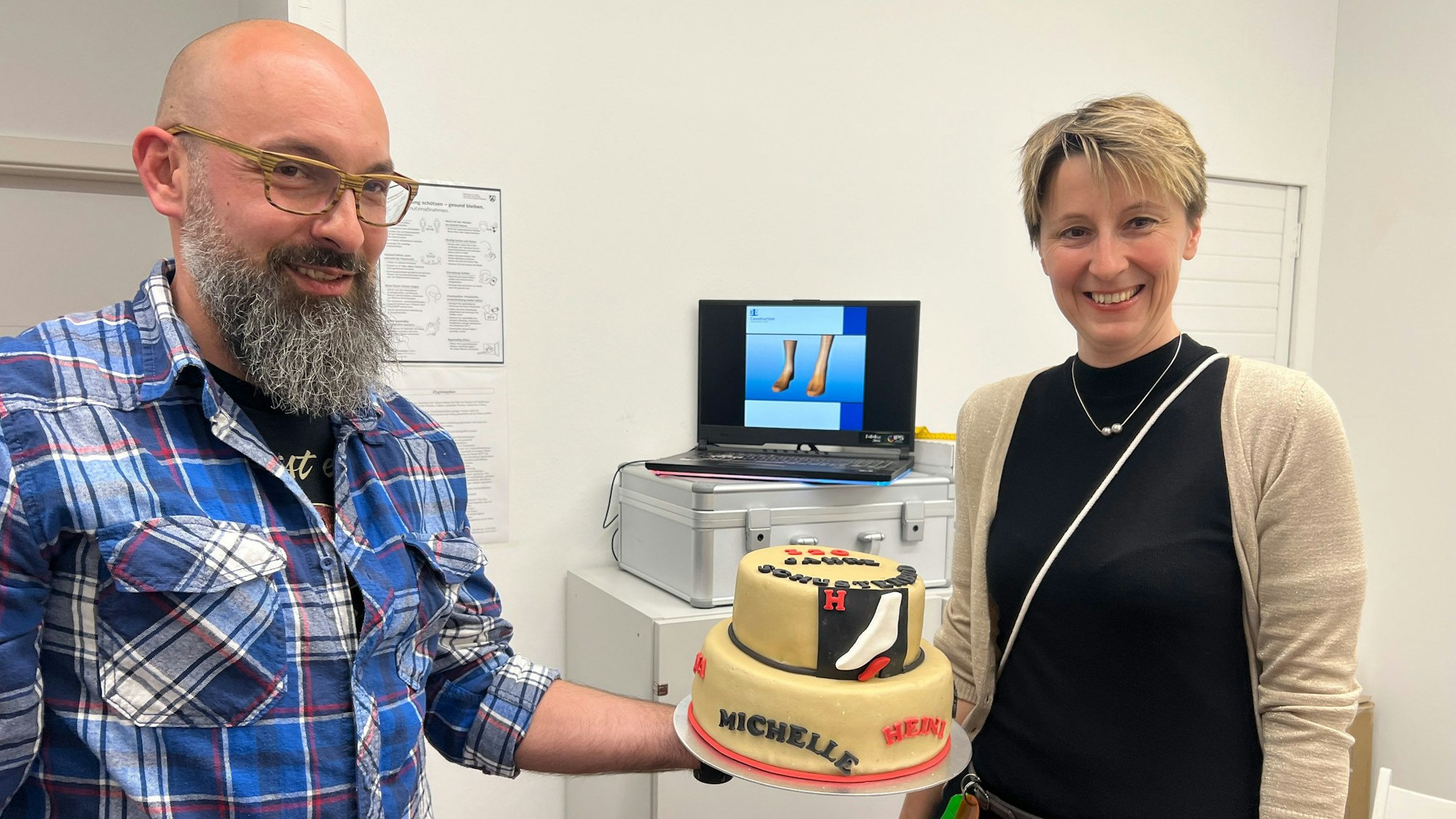 Thomas Ohlig, Orthopädie-Schumachermeister und Inhaberin Jessica Hohenschon mit der Geburtstagstorte.