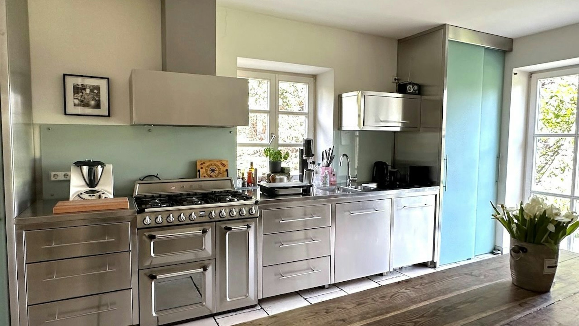 Eine Küchenzeile mit Edelstahlfronten ist zu sehen.