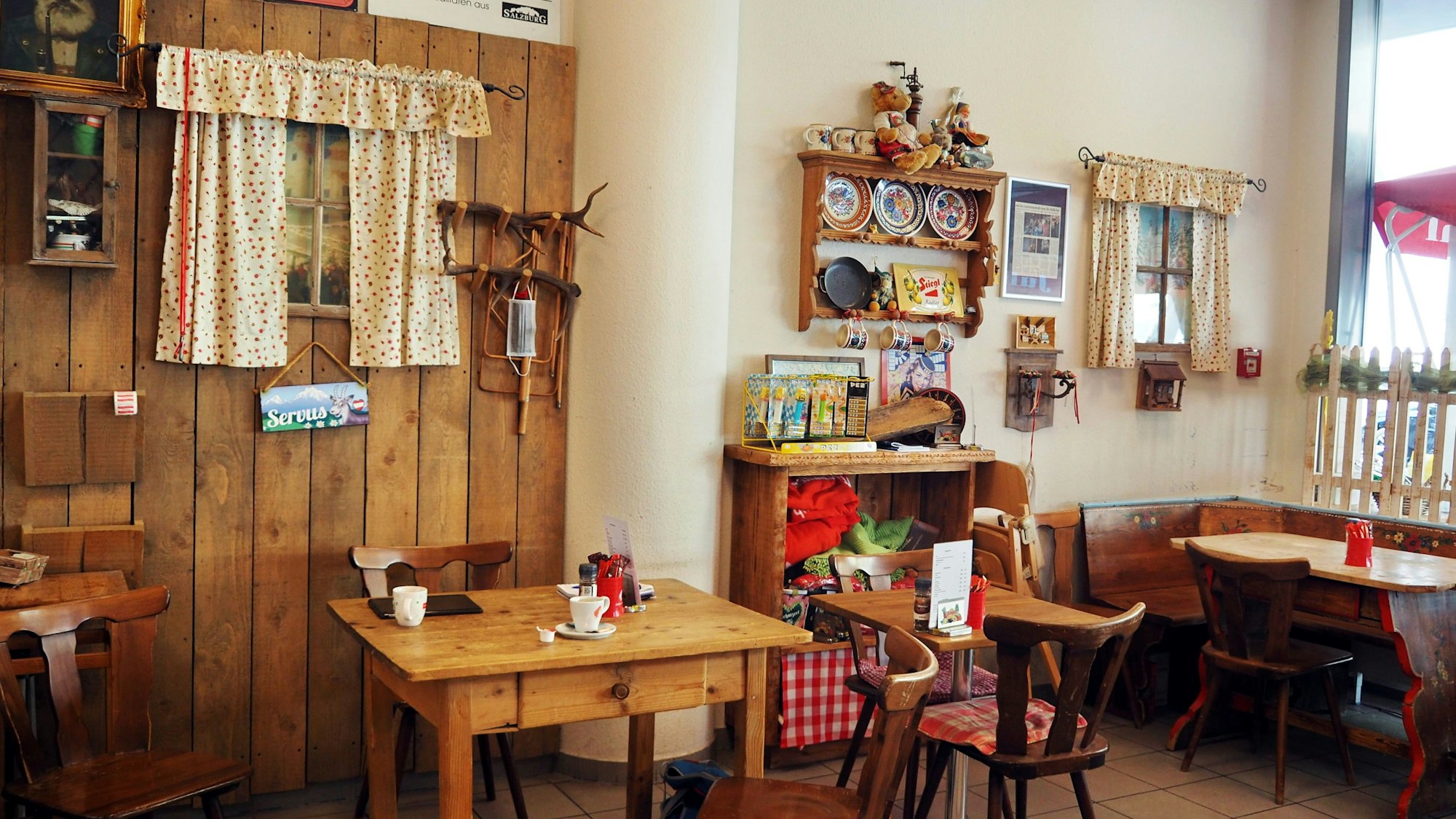 Holztische und -stühle stehen im Feinkostladen.