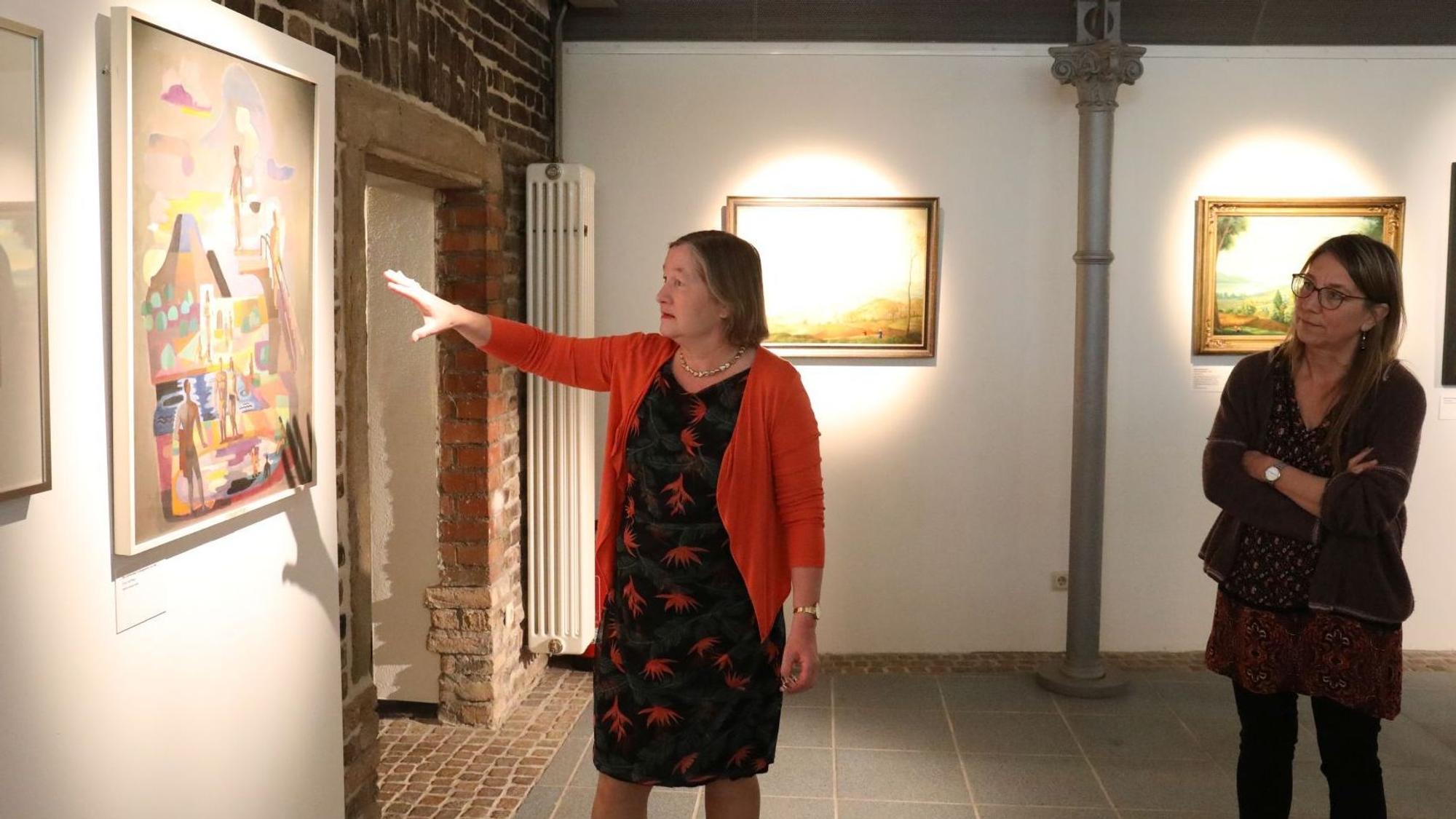 Zwei Frauen in einer Ausstellung mit Arbeiten von Carlo Mense.
