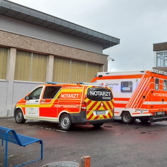 Ein Rettungswagen und ein Notarztwagen stehen auf dem Hof der Gesamtschule in Lohmar.