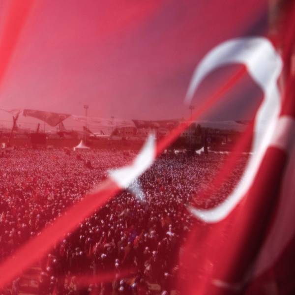 Anhänger des türkischen Präsidenten und Präsidentschaftskandidaten der Volksallianz Erdogan bei einer Wahlkampfveranstaltung hinter einer türkischen Fahne.