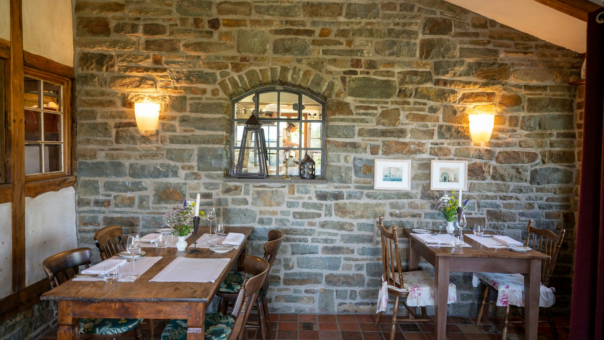 Tische stehen vor einer Steinwand