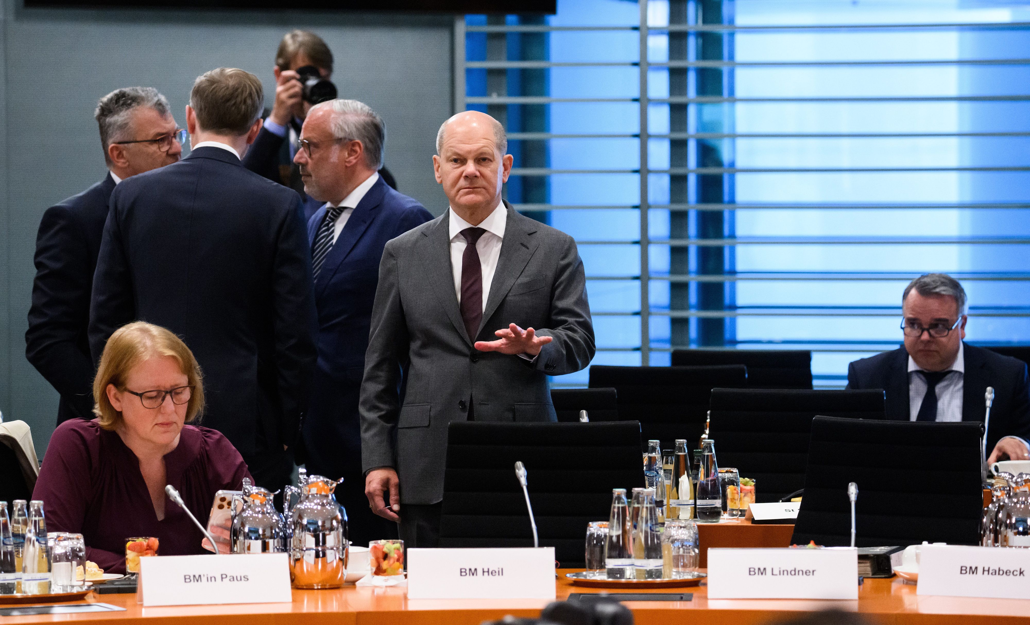 Berlin: Bundeskanzler Olaf Scholz (SPD) steht zu Beginn des Bund-Länder-Gipfels im Bundeskanzleramt. Neben ihm sitzt Lisa Paus (Bündnis 90/Die Grünen), Bundesministerin für Familie, Senioren, Frauen und Jugend.