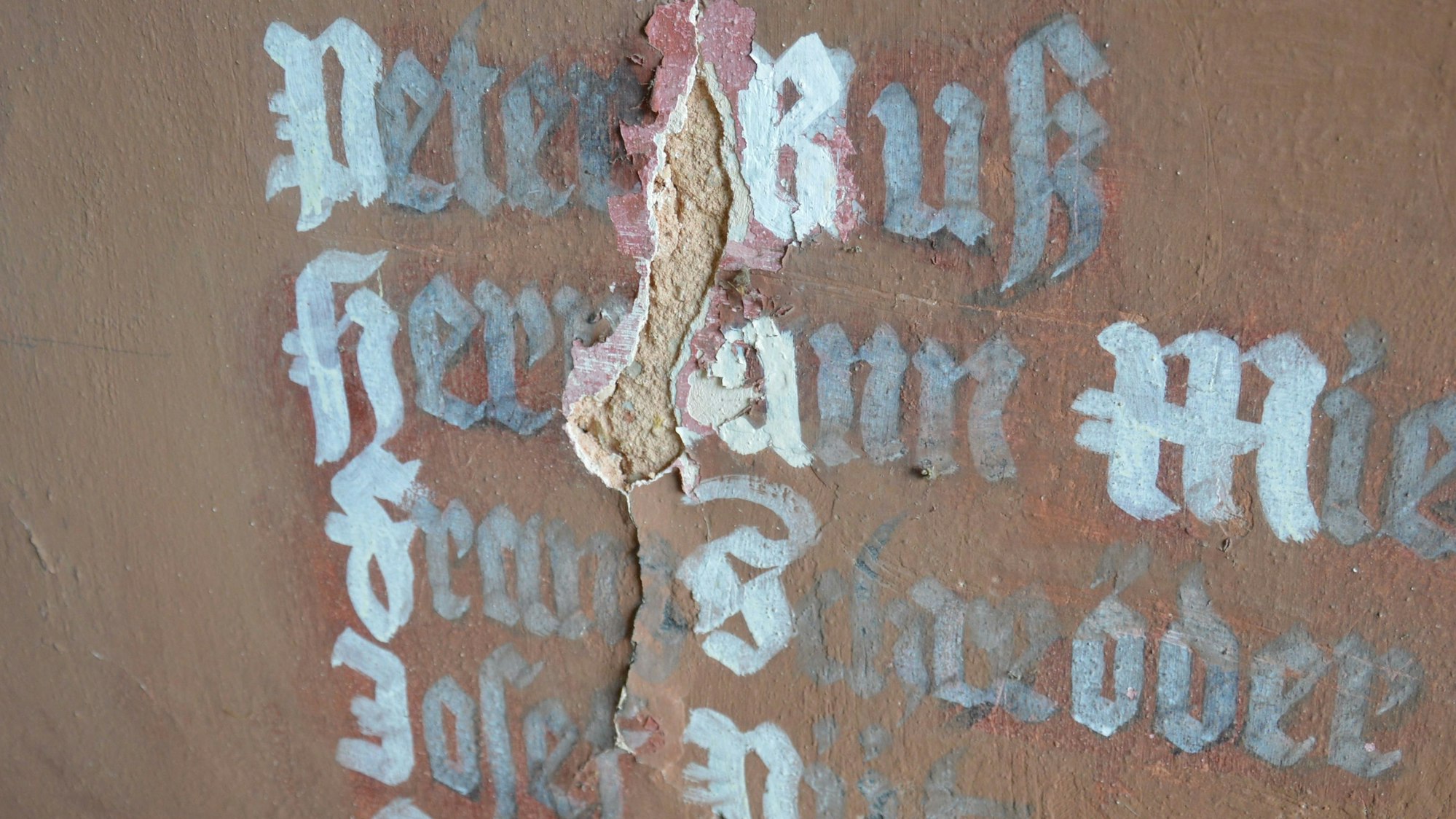 Ein Riss zieht sich durch die Schrift mit den Namen Gefallener.