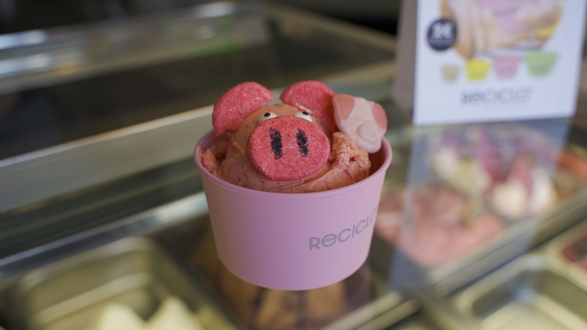 Das Foto zeigt einen lilafarbenen Eisbecher mit Eiskugeln.