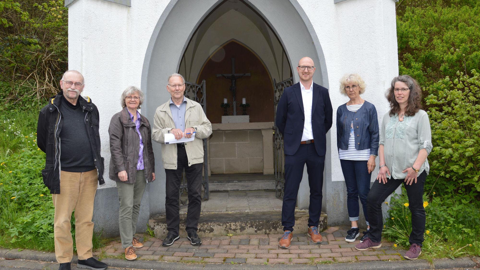 Die Vertreter von Stadt und Pfarre sowie Heinz Vaßen vor der weiß getünchten Pestkapelle in Schleiden.