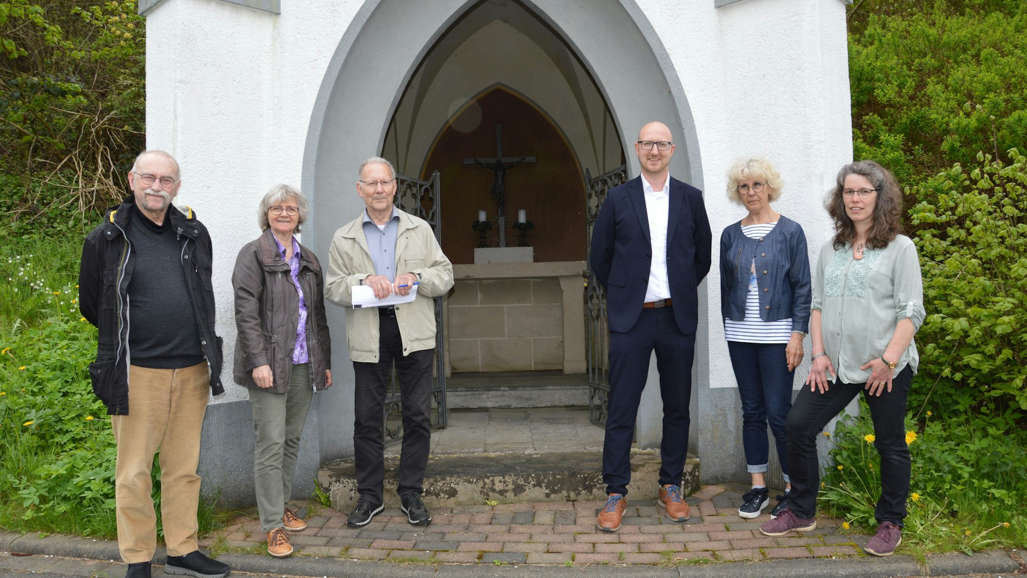 Die Vertreter von Stadt und Pfarre sowie Heinz Vaßen vor der weiß getünchten Pestkapelle in Schleiden.