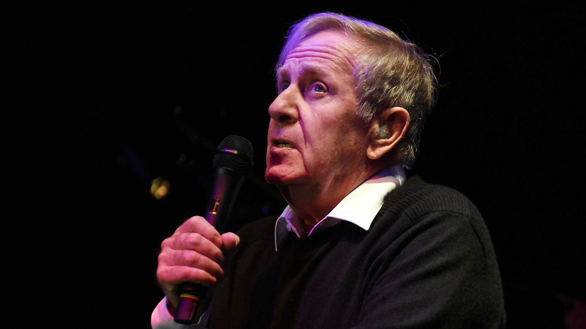 Im Bild ist der Sänger Stephan mit einem Mikrofon.