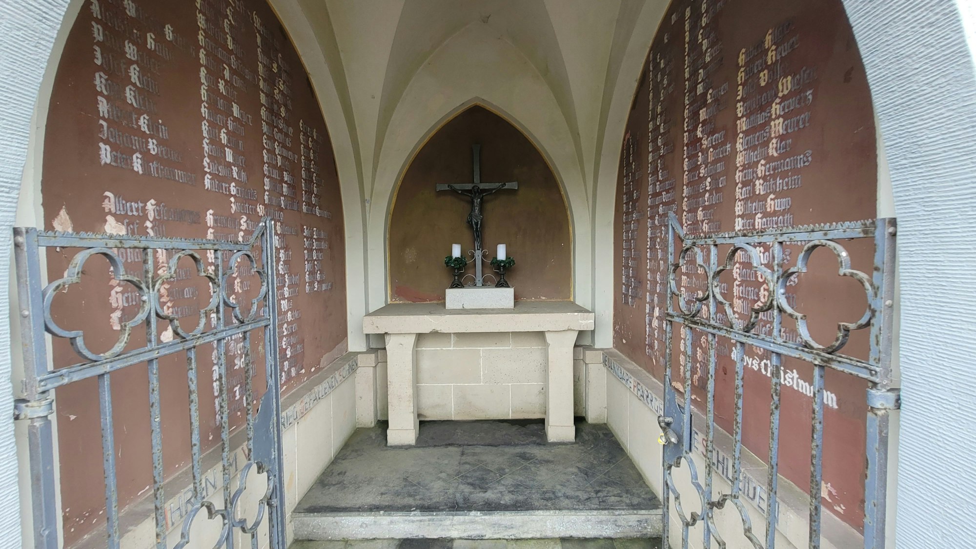 Der Blick durchs schmiedeeiserne Tor ins Innere der Kapelle. An den Seiten die Tafeln mit den Namen der in den beiden Weltkriegen gestorbenen Schleidener.