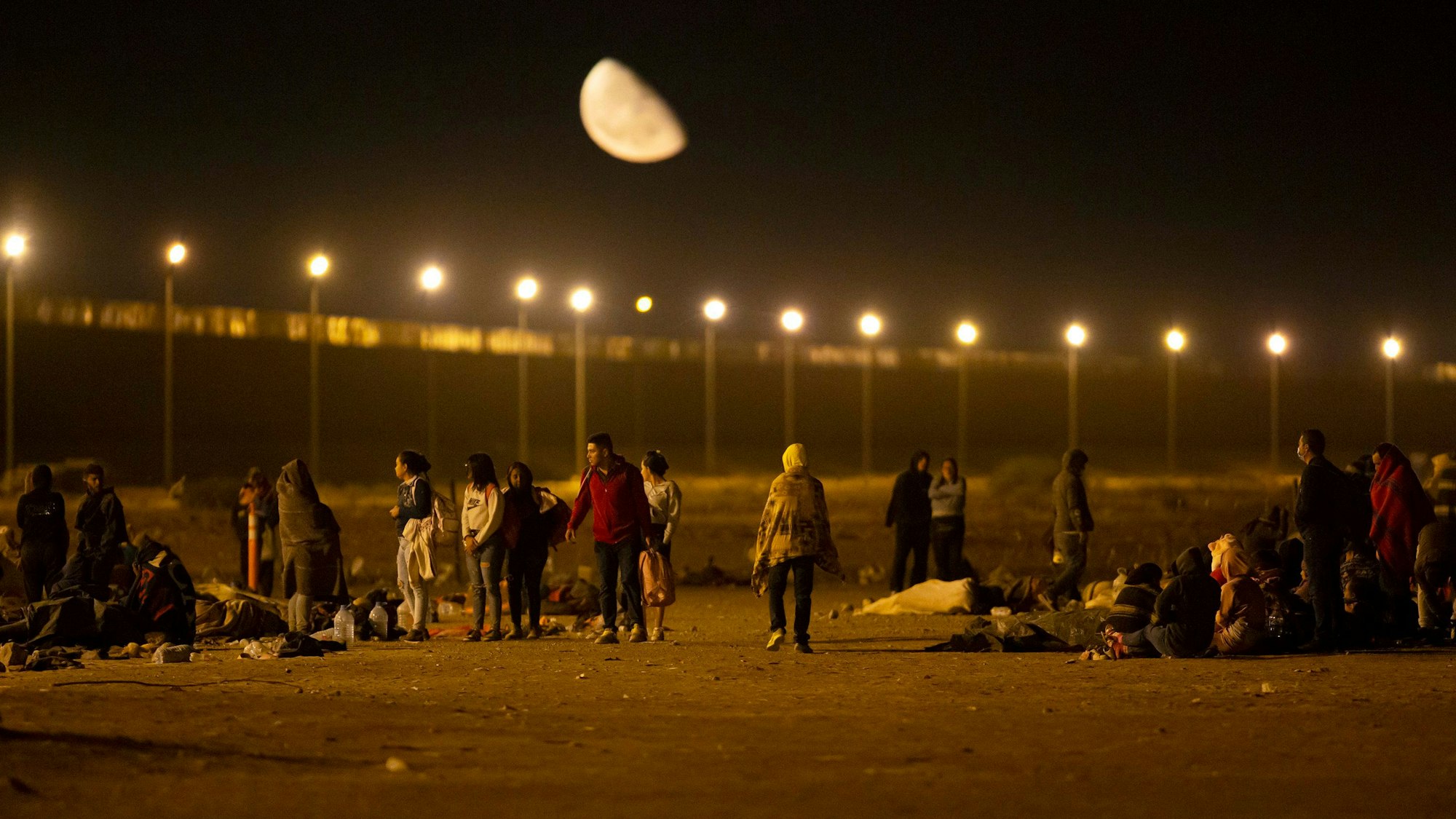11.05.2023, USA, El Paso: Migranten kommen in den frühen Morgenstunden an einem Tor im Grenzzaun an, nachdem sie von Ciudad Juarez, Mexiko, nach El Paso, Texas, gegangen sind. I