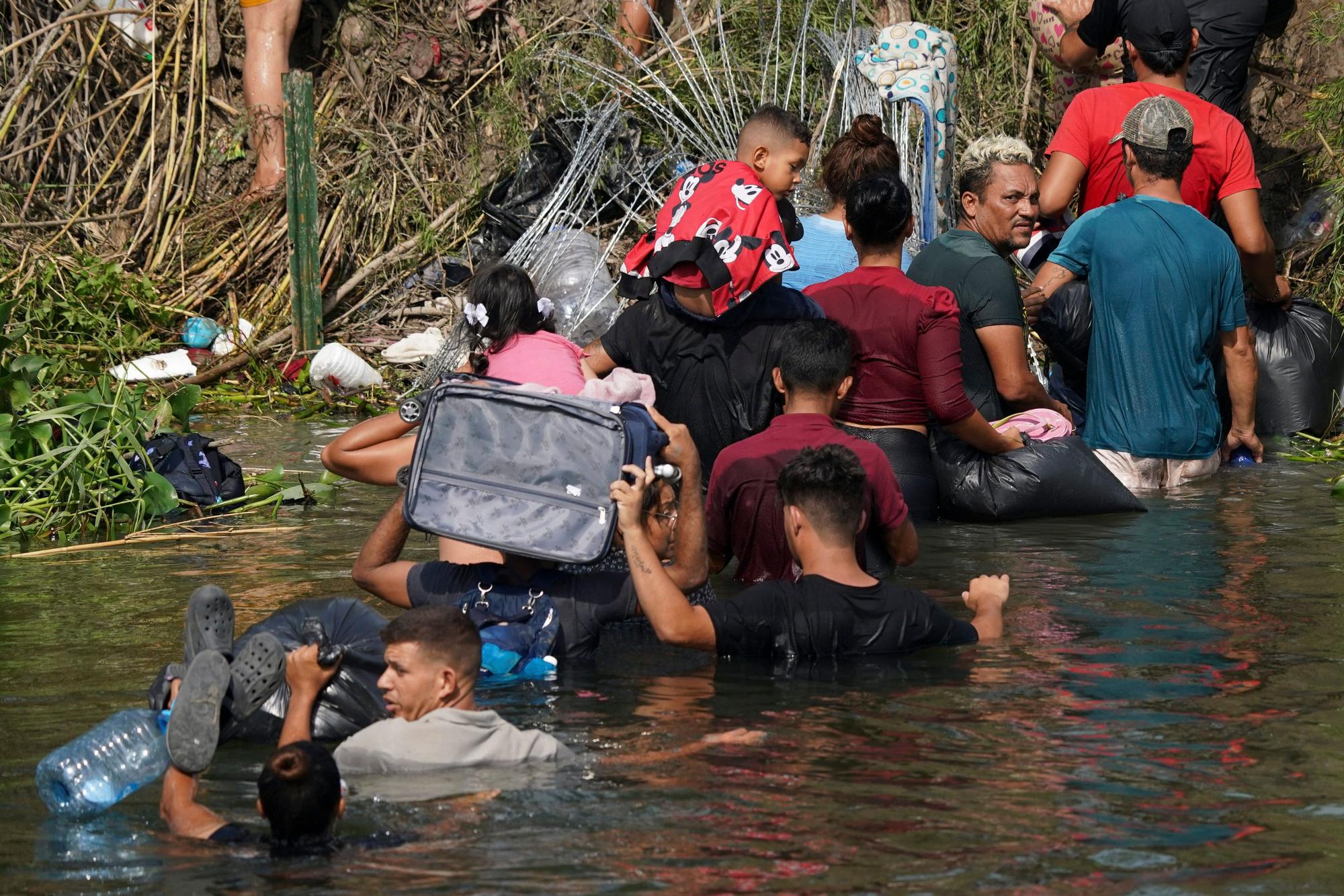 Matamoros: Der venezolanische Migrant Luis Parra (3.v.r) überquert zusammen mit anderen Migranten den Rio Grande. Am 11. Mai fällt eine umstrittene Abschiebepraxis, die sogenannte Titel-42-Regelung, weg.