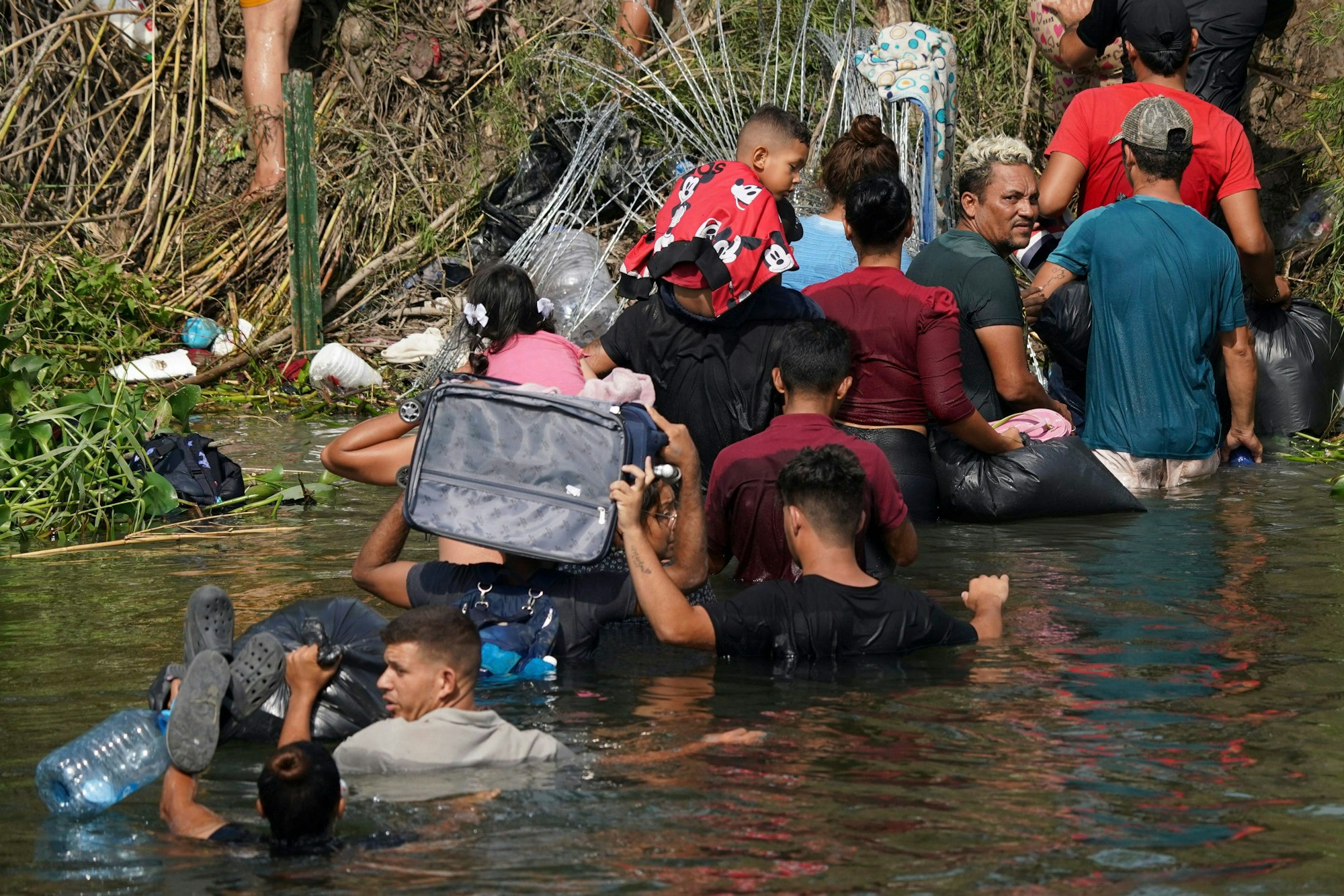 Matamoros: Der venezolanische Migrant Luis Parra (3.v.r) überquert zusammen mit anderen Migranten den Rio Grande. Am 11. Mai fällt eine umstrittene Abschiebepraxis, die sogenannte Titel-42-Regelung, weg.