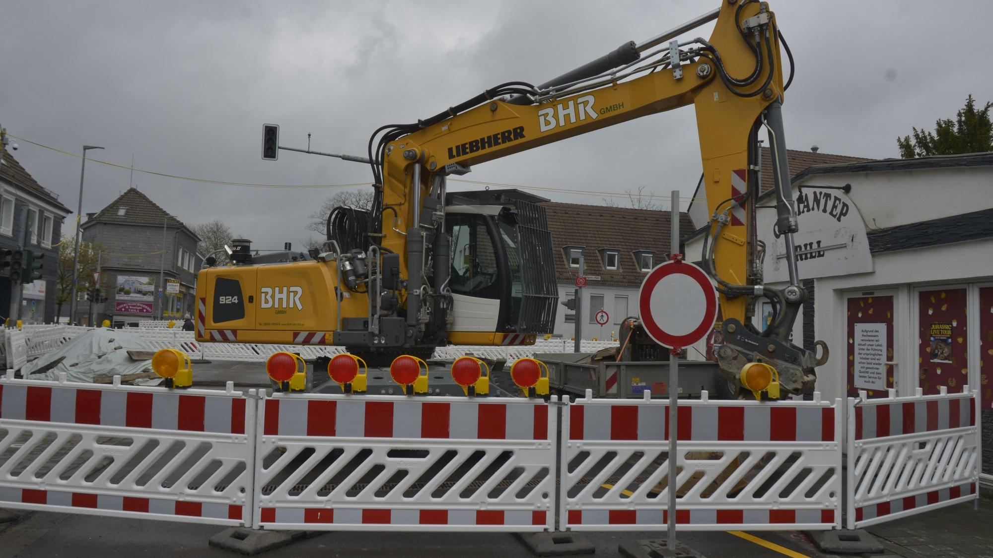 Die Baustelle ist zu sehen. Ein Bagger steht hinter der Absperrung.