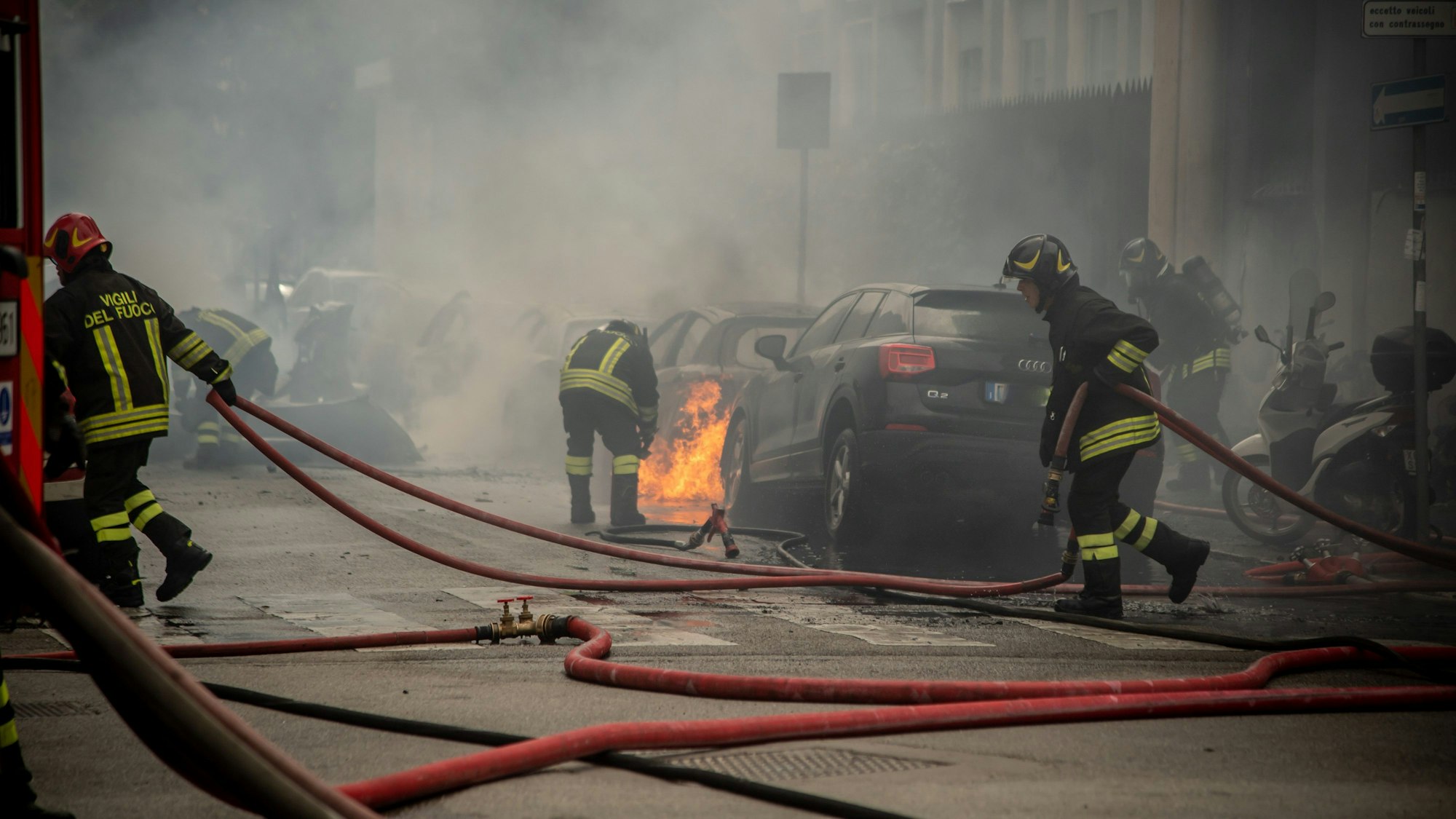 11.05.2023, Italien, Mailand: Feuerwehrleute löschen Autos nach einer Explosion in der Innenstadt. Laut Medienberichten geriet nach ersten Erkenntnissen ein Kleinlaster in Brand, der Sauerstoffflaschen transportierte. Mindestens eine davon explodierte, in der Folge fingen etliche Autos Feuer. Foto: Claudio Furlan/LaPresse via ZUMA Press/dpa +++ dpa-Bildfunk +++