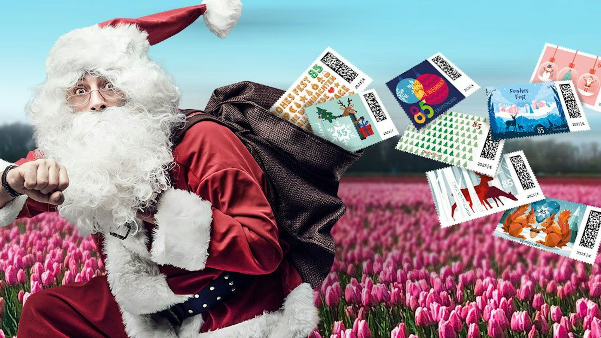 Die acht neuen Briefmarken fallen aus dem Sack des Weihnachtsmanns.