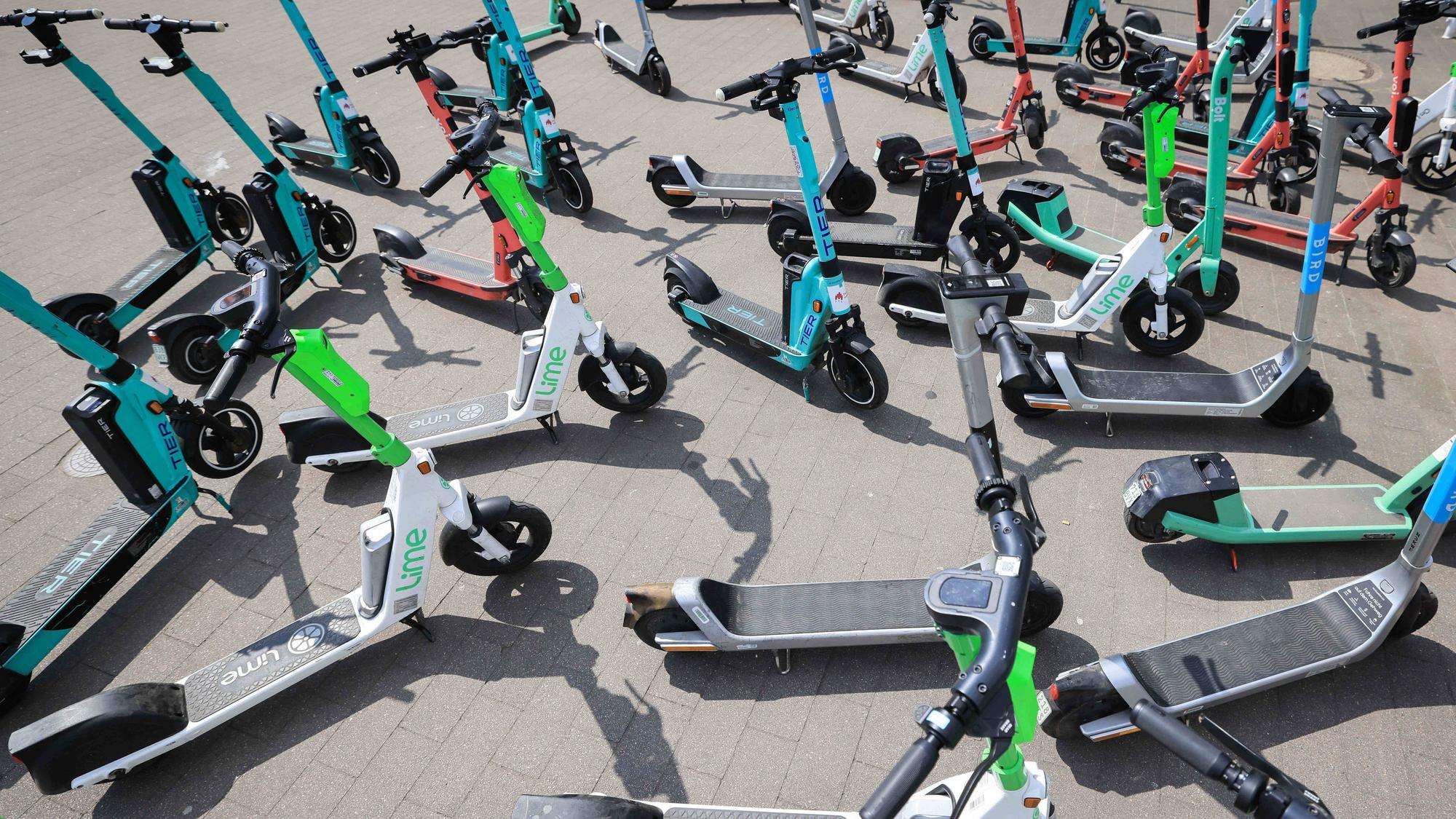 Viele E-Scooter verschiedener Anbieter stehen durcheinander.