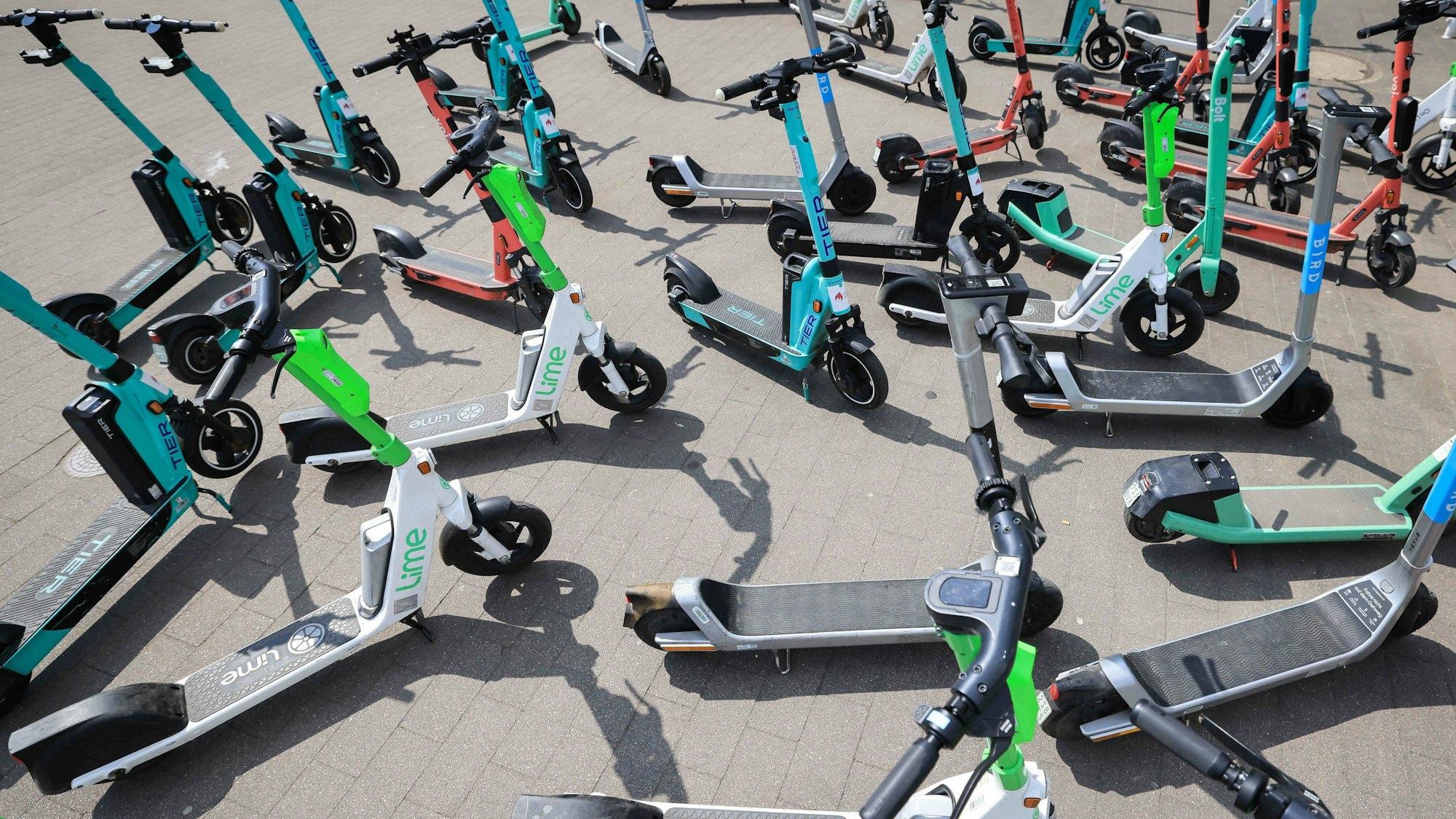 Viele E-Scooter verschiedener Anbieter stehen durcheinander.
