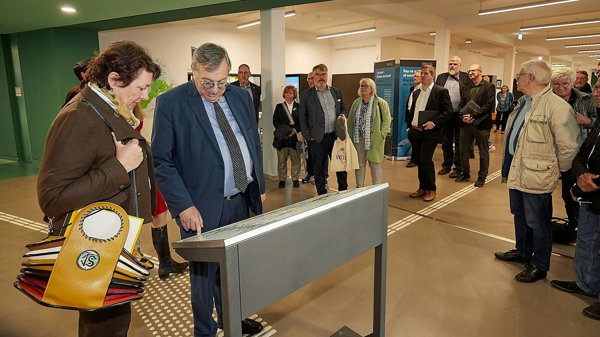 Das Foto zeigt die Teilnehmer der Ausstellungseröffnung an der Karte von Vogelsang.