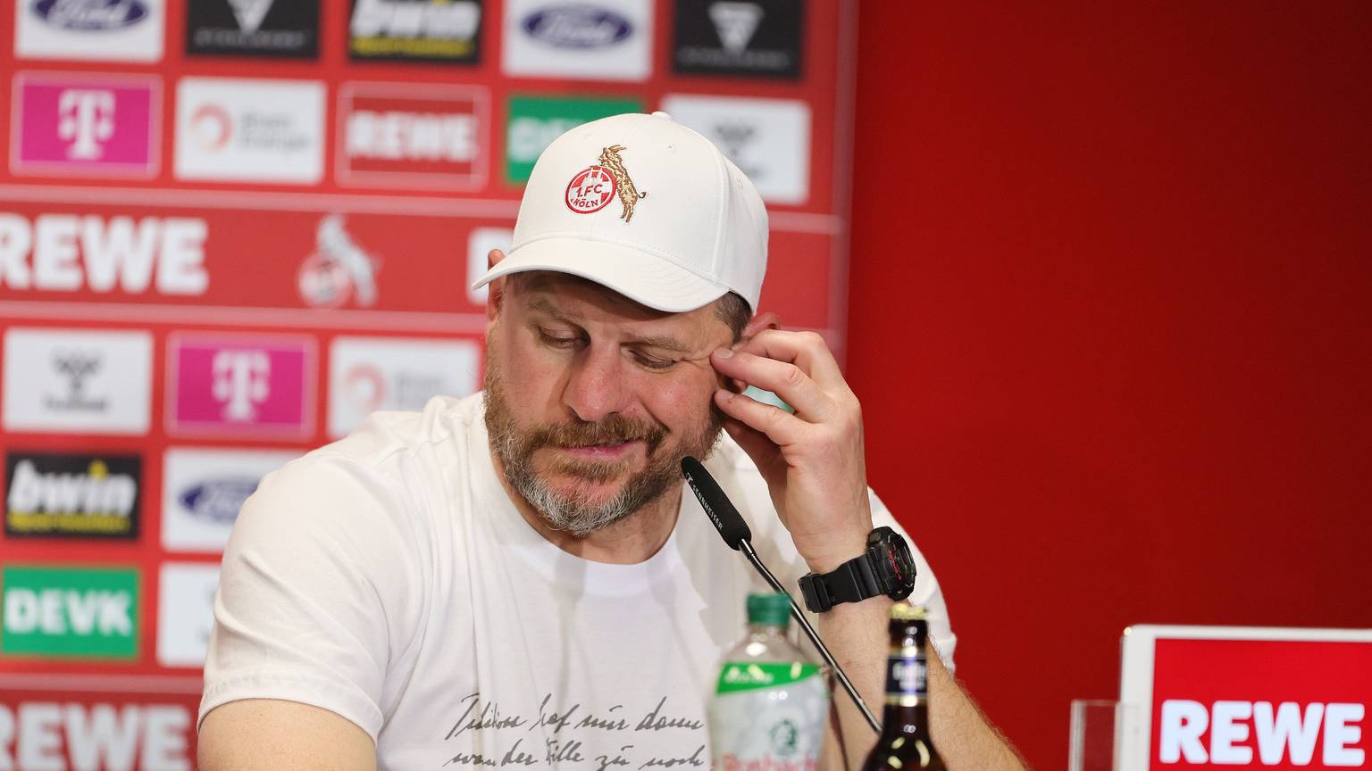 Steffen Baumgart, Trainer des 1. FC Köln, bei einer Pressekonferenz am Geißbockheim. Baumgart sitzt vor einem Mikrofon, im Hintergrund ist eine Wand mit Sponsoren zu sehen.