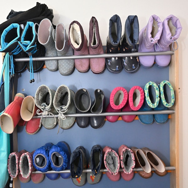 Schuhe und Stiefel hängen an einer Garderobe.