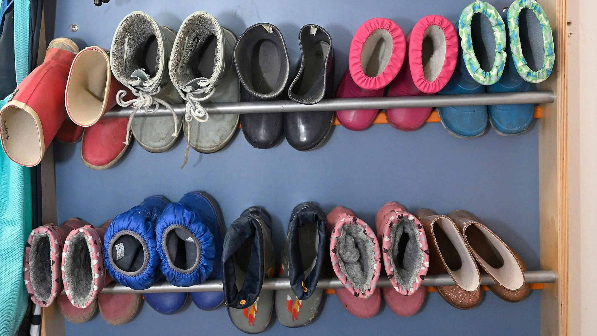 Schuhe und Stiefel hängen an einer Garderobe.